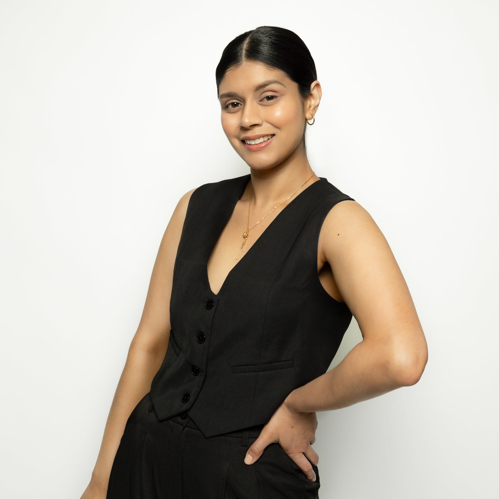 Photo of the model wearing the gold It's Written' Anemone Necklace while posing for the camera.