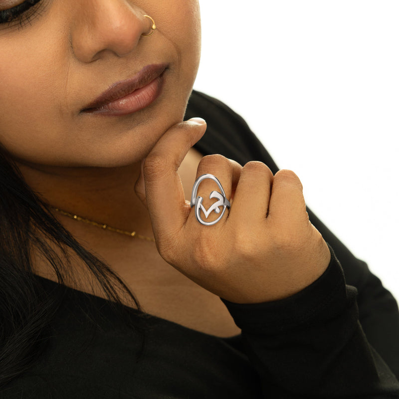 Close-up of the silver Jaan Ring worn on hand pimage_ showing the open oval shape with curved calligraphy detailing.