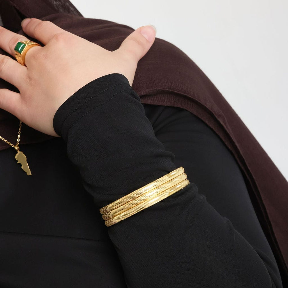 Close up of the left hand of the model showing the three fold Keffiyeh bangles.