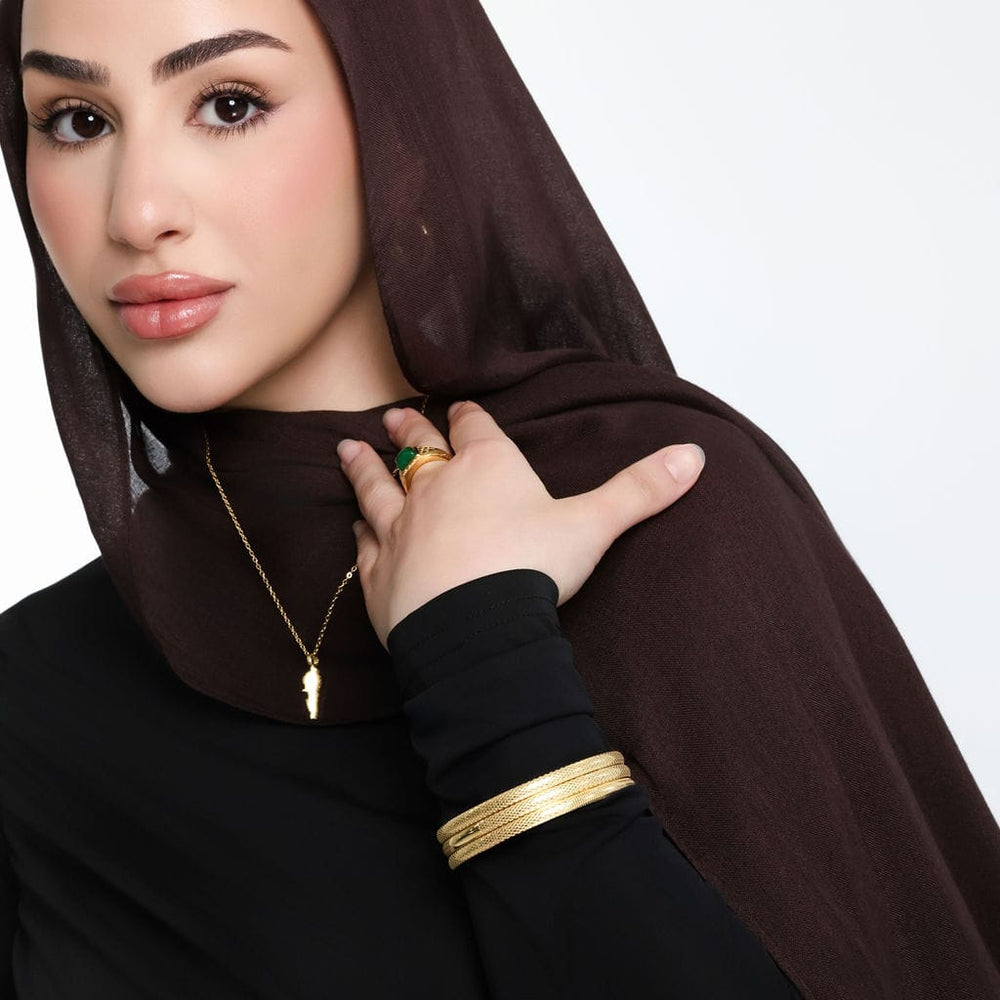 Photo of the model wearing three pieces of gold Keffiyeh Bangle