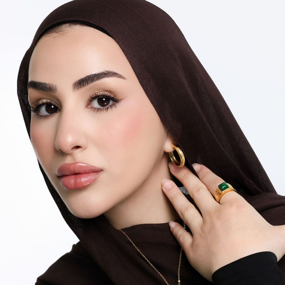 Photo of the model wearing the gold Keffiyeh Mini Hoops on their left ear.