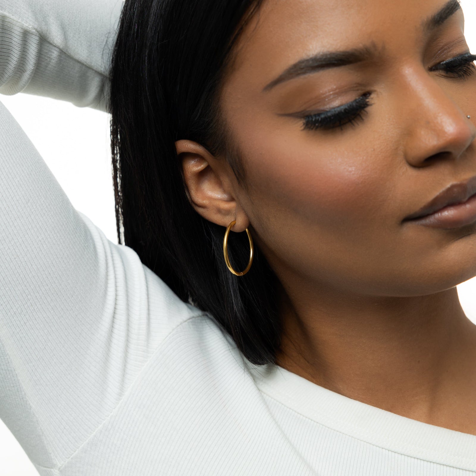 Photo of the model wearing the gols Large Essential Hoops | 25mm on their right ear.
