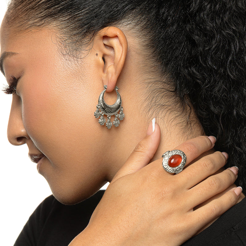 Woman wearing silver Levantine Garden Hoop Earrings with floral engraving and dangling charms pimage_ shown in a side profile pose.