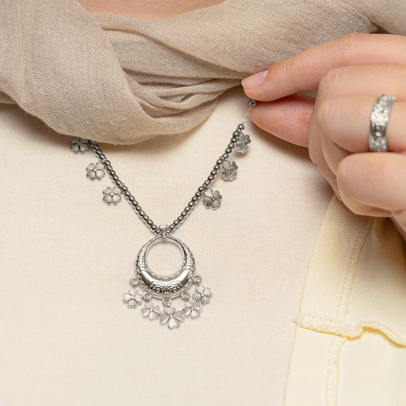 Close-up of a hand holding the chain of the silver Levantine Garden Necklace