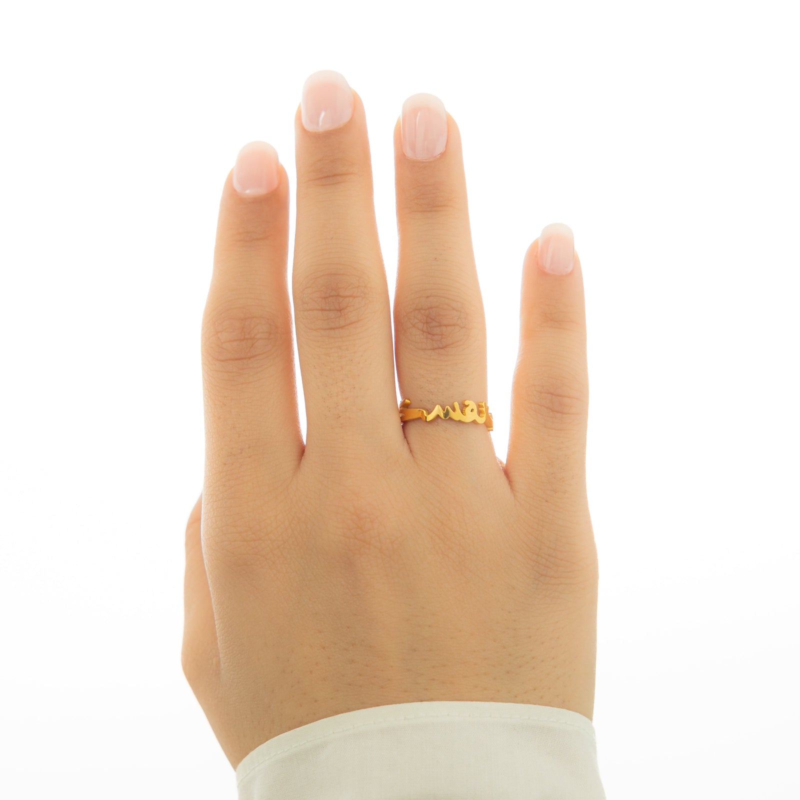A hand wearing a gold "Love Yourself First" ring.