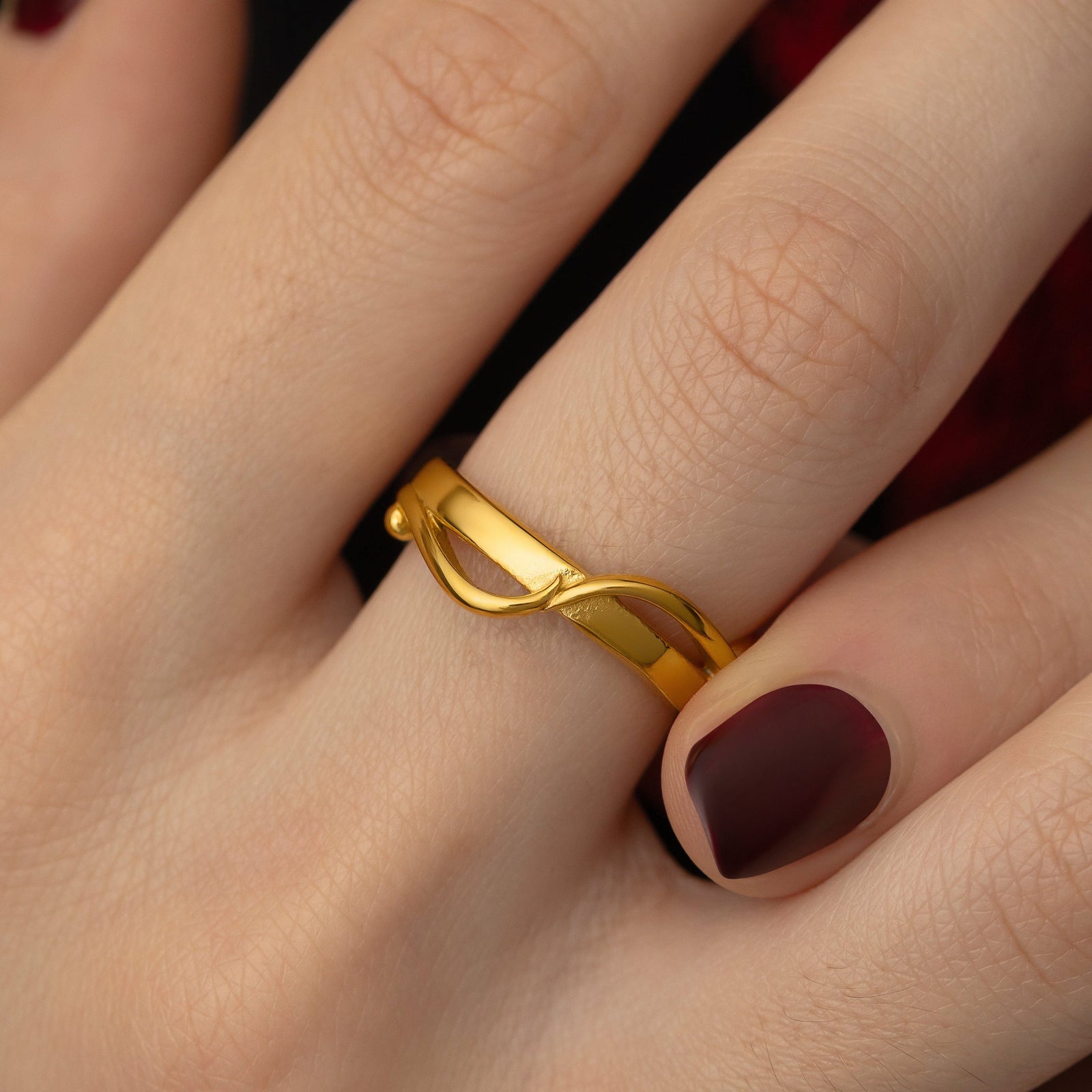 Close up photo of gold the Love | حب Intertwined Ring worn by the model.