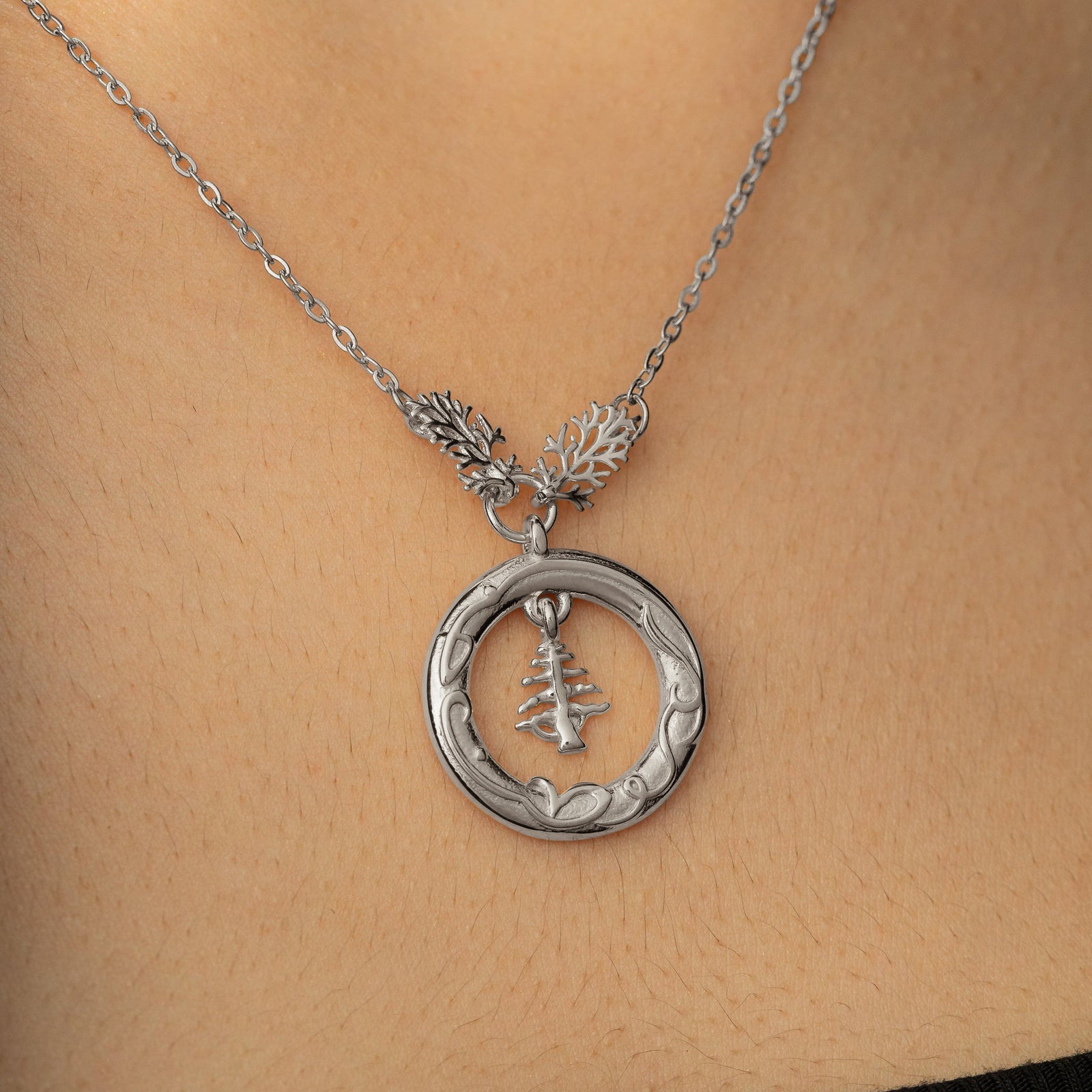 Close up photo of the Love of the Homeland Lebanon Cedar silver pendant as worn by a model