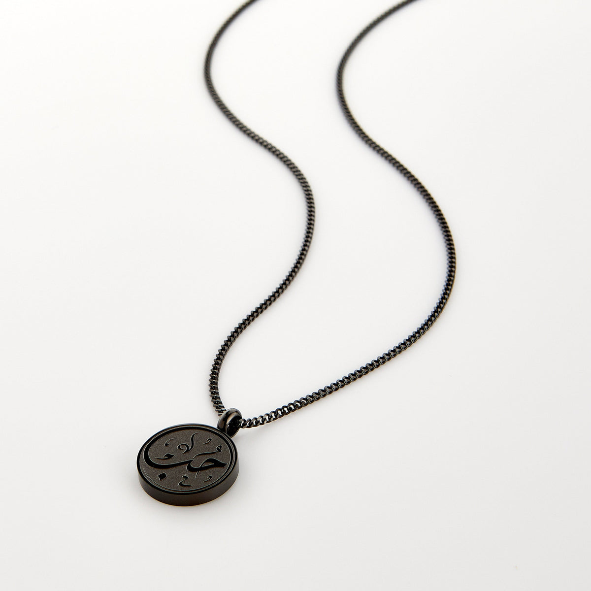 Black necklace with a circular pendant engraved with 'Hub' calligraphy, displayed on a white background.