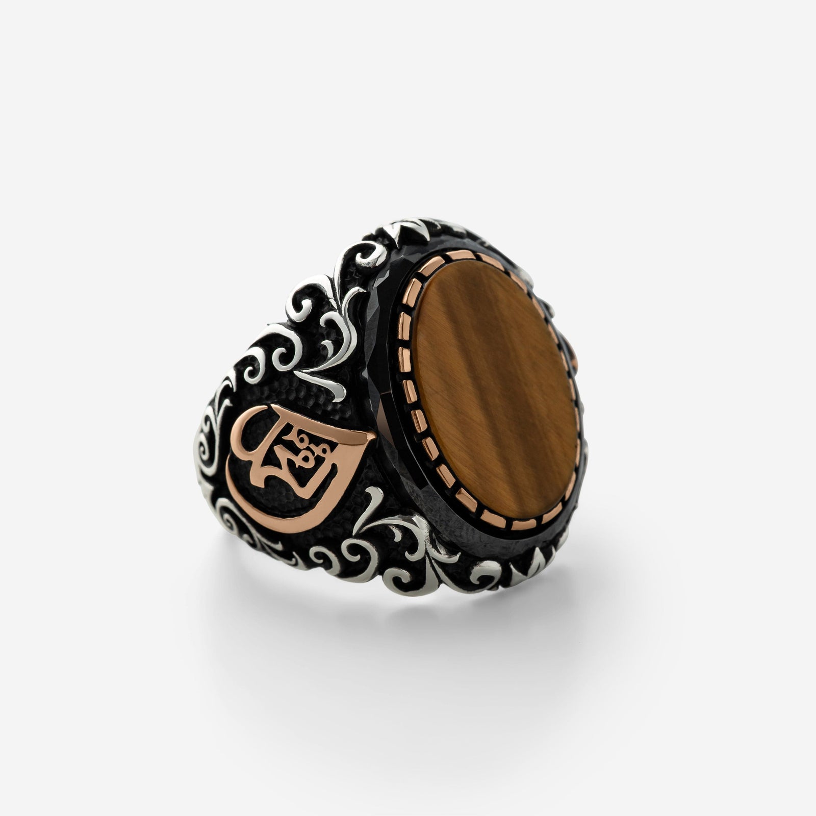 Close up of the Allah Tiger's Eye Sterling Silver Ring against a light background.