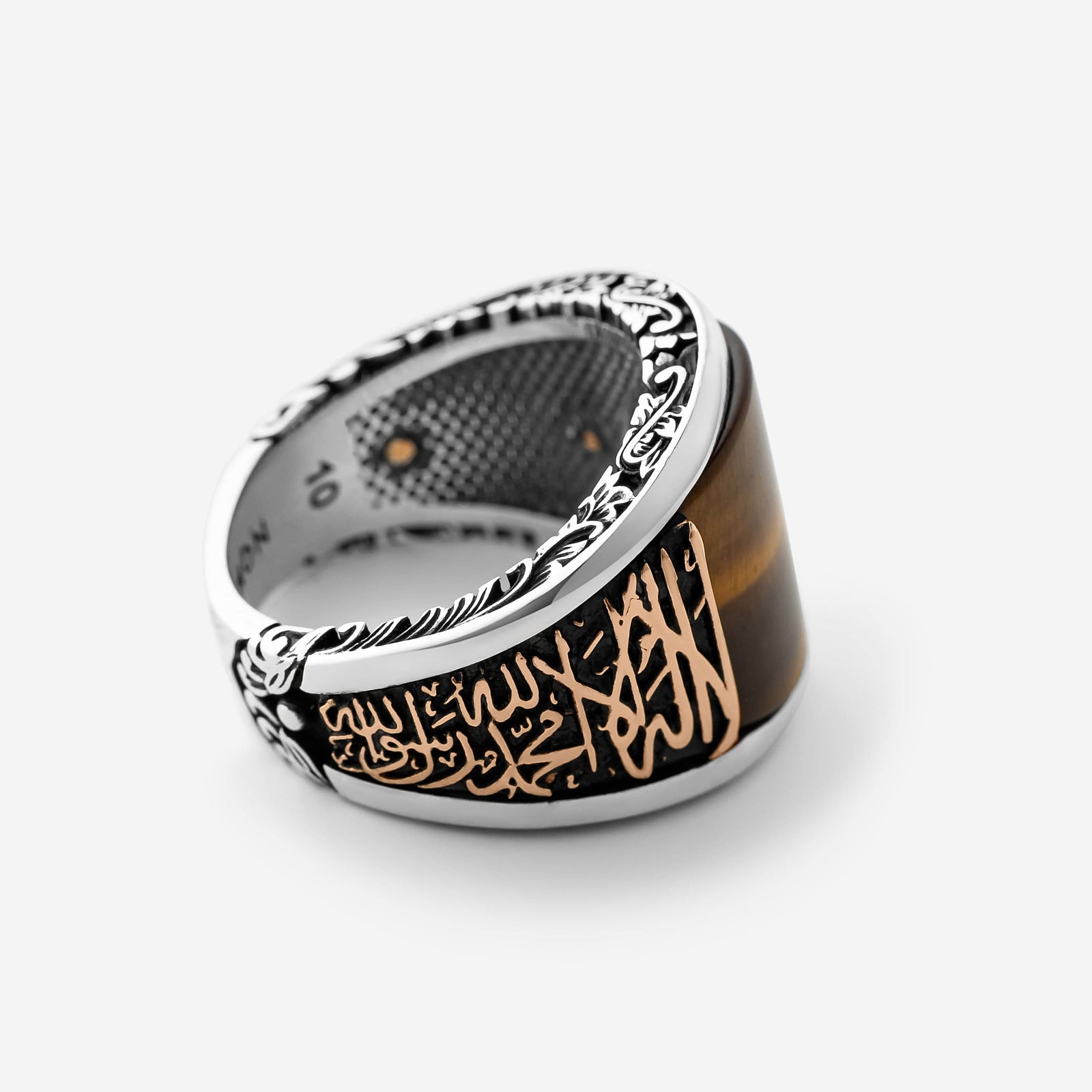 Close up of the Shahada Tiger's Eye Sterling Silver Ring against a light background.