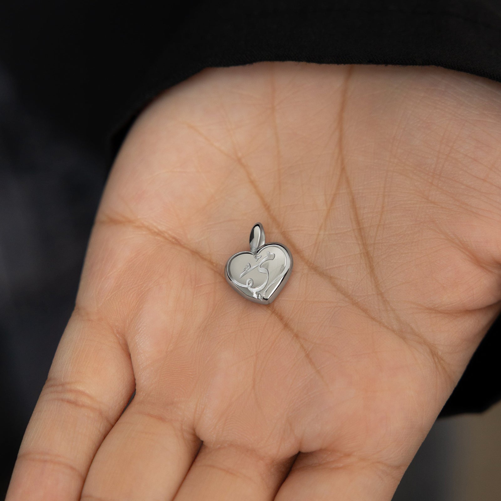 Close up of the silver Mama Heart Charm on the model's left hand.