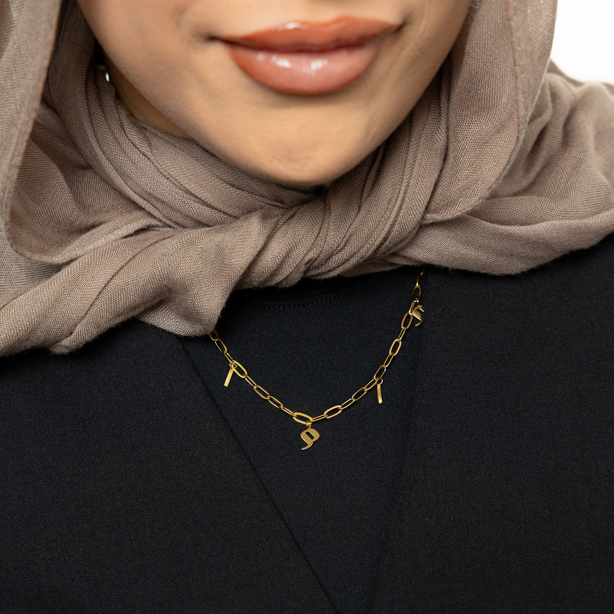 Close up of the gold Mama Charm Necklace as worn by the model.
