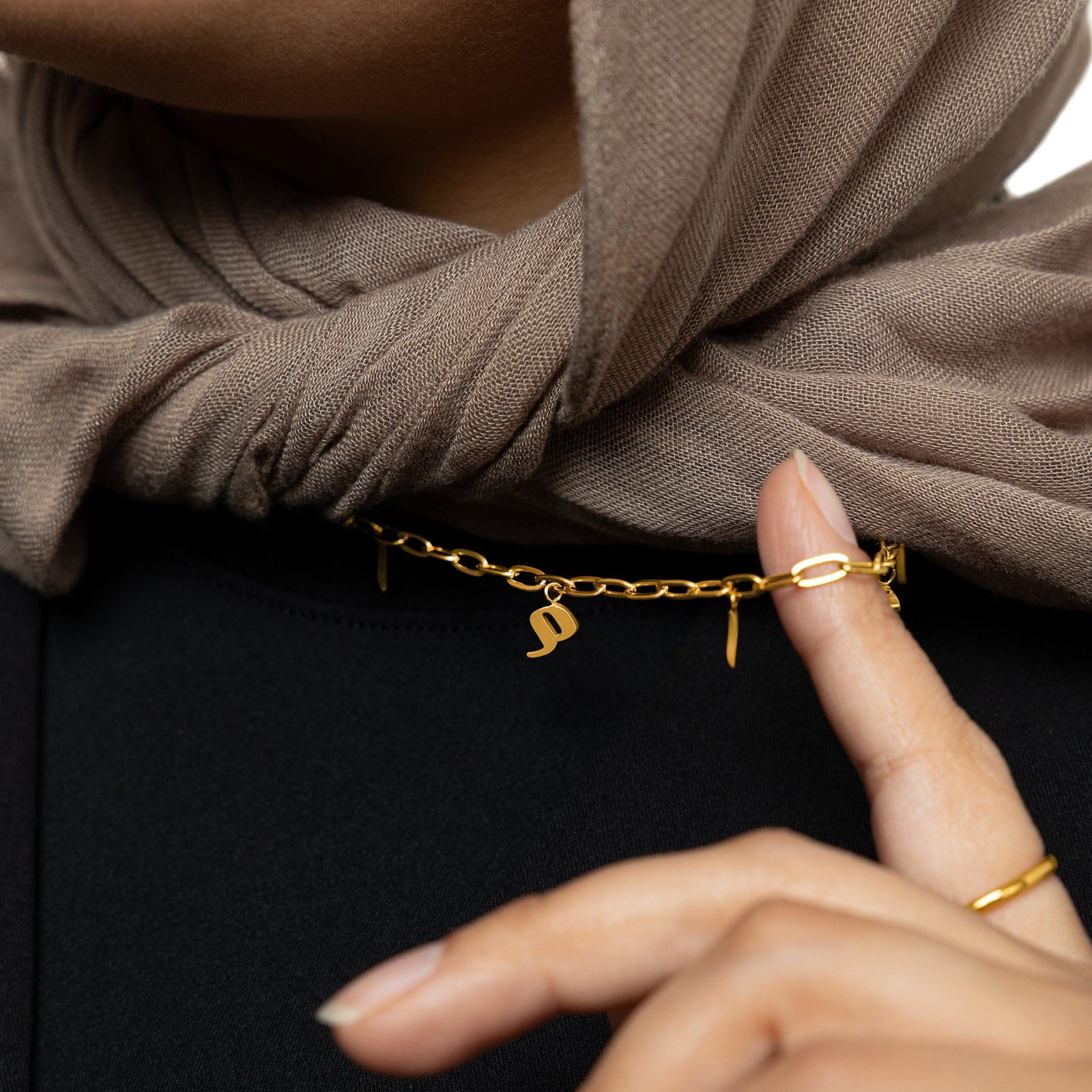 Close up of the gold Mama Charm Necklace as worn by the model.
