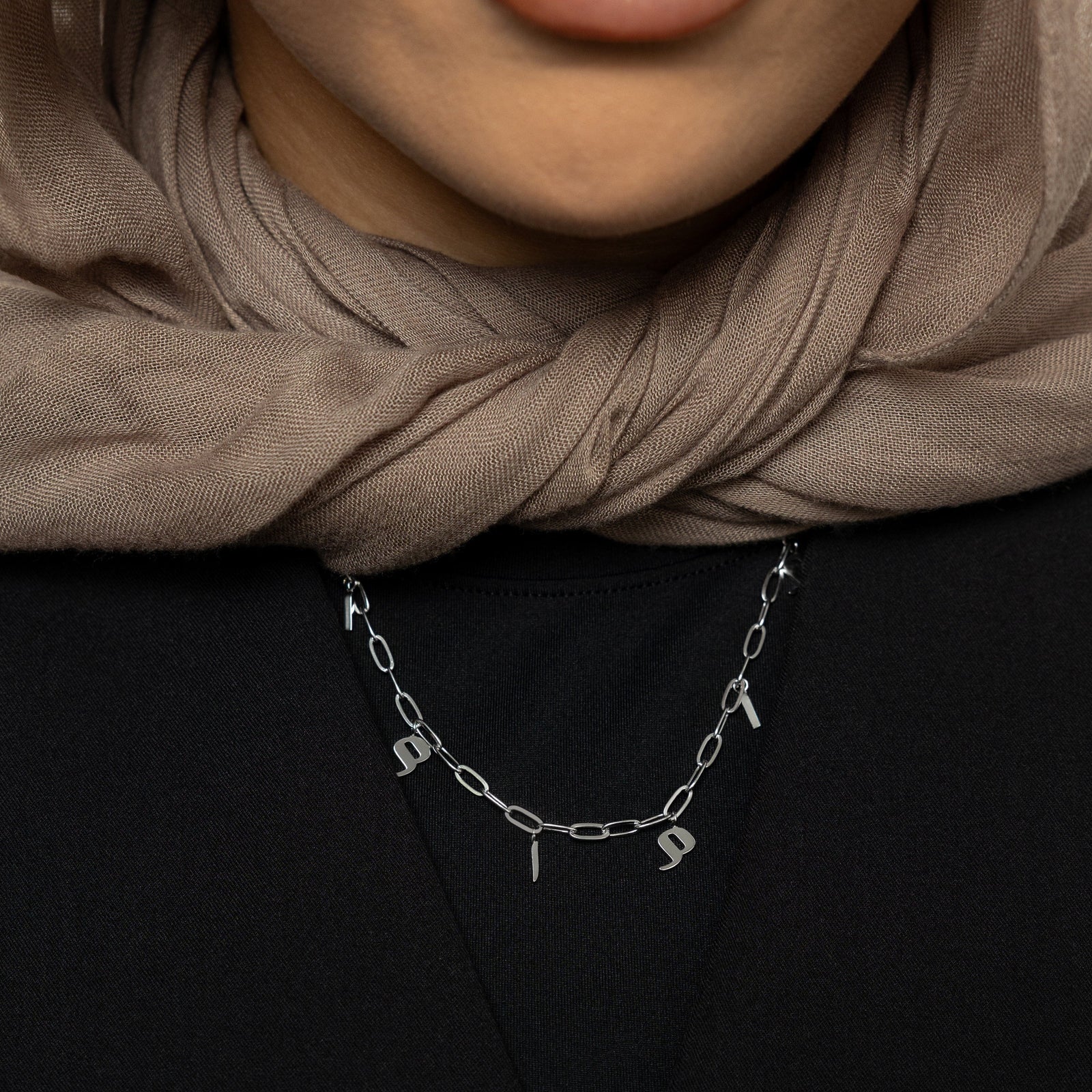 Close up of the silver Mama Charm Necklace as worn by the model.