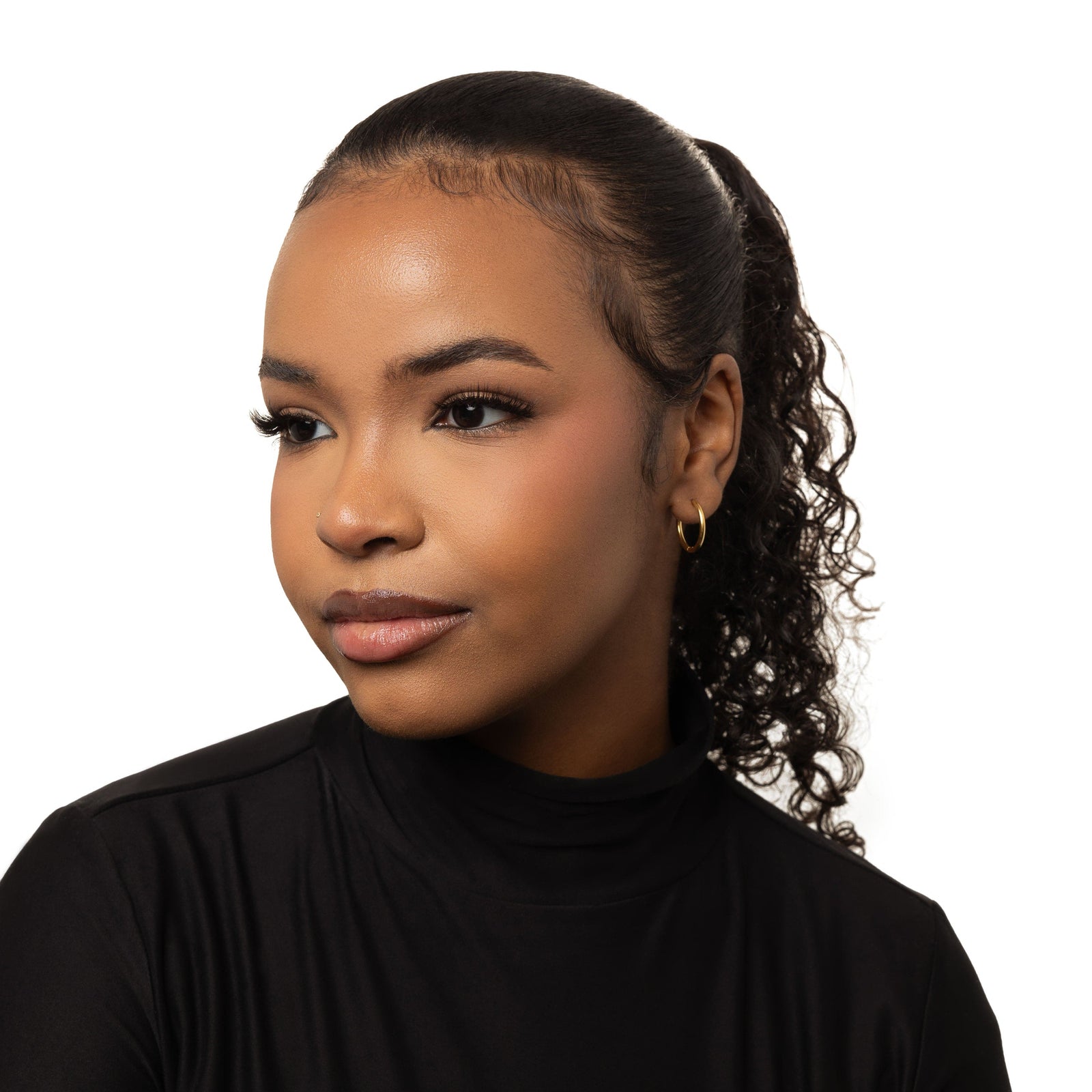 Photo of the model wearing the gold Medium Essential Hoops | 16mm on their left ear.