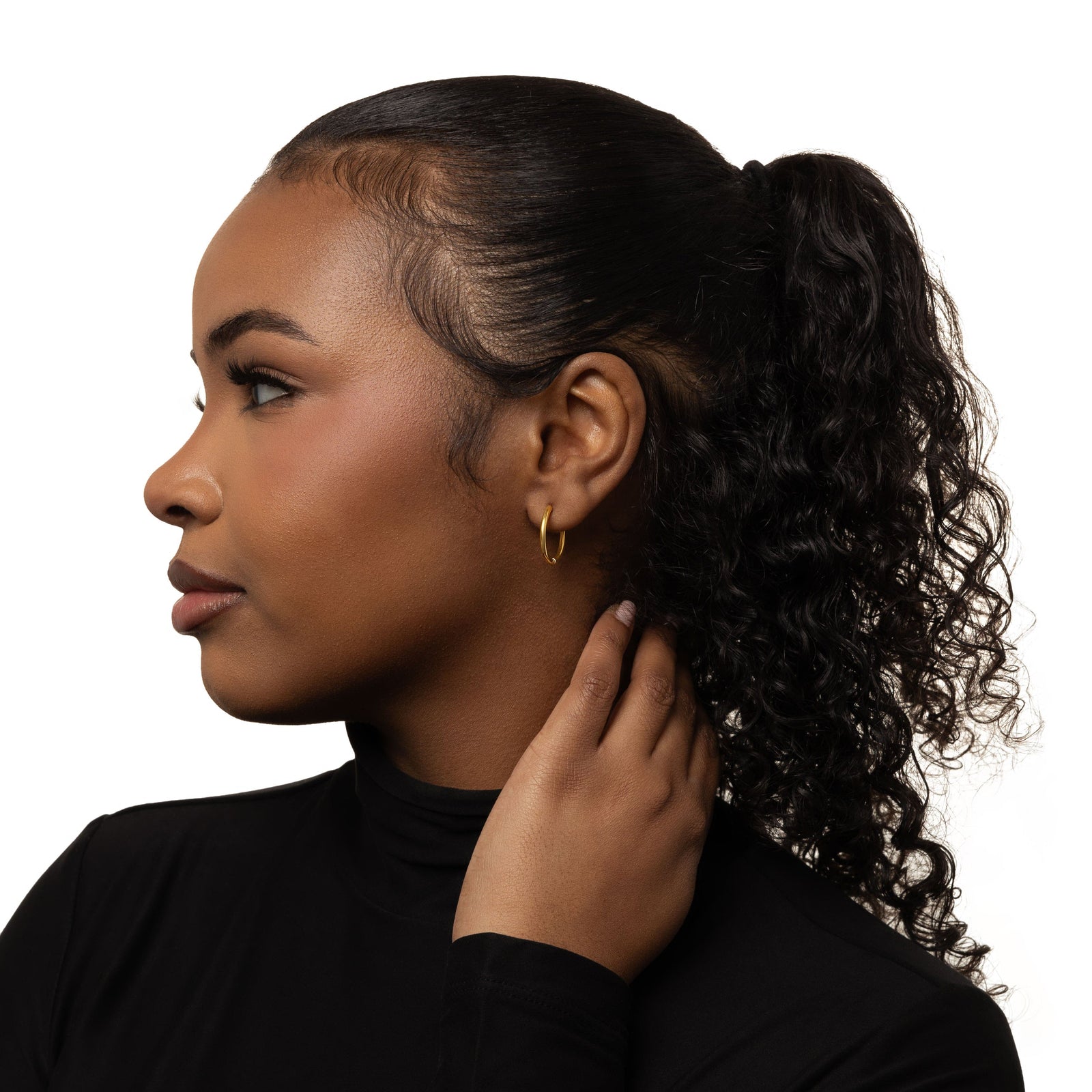 Photo of the model's left side profile. the model is wearing the gold Medium Essential Hoops | 16mm on their left ear.