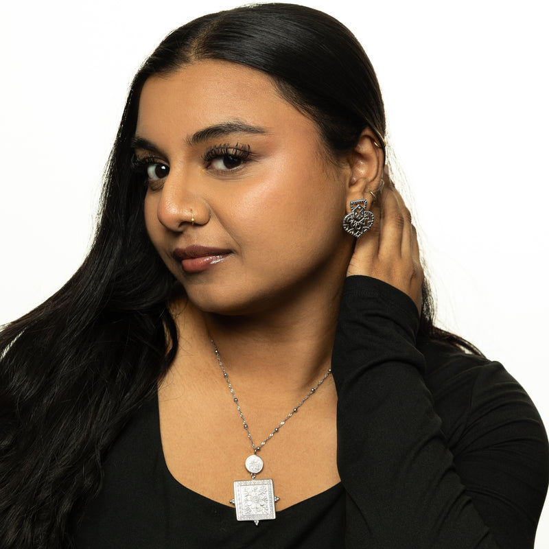 Woman wearing the silver Mehndi Heart Earring with hair tucked behind ear.