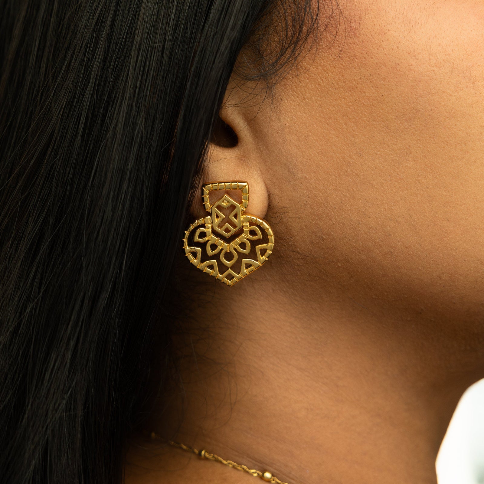 Close-up of the gold Mehndi Heart Earring on ear, showing detailed geometric heart design.