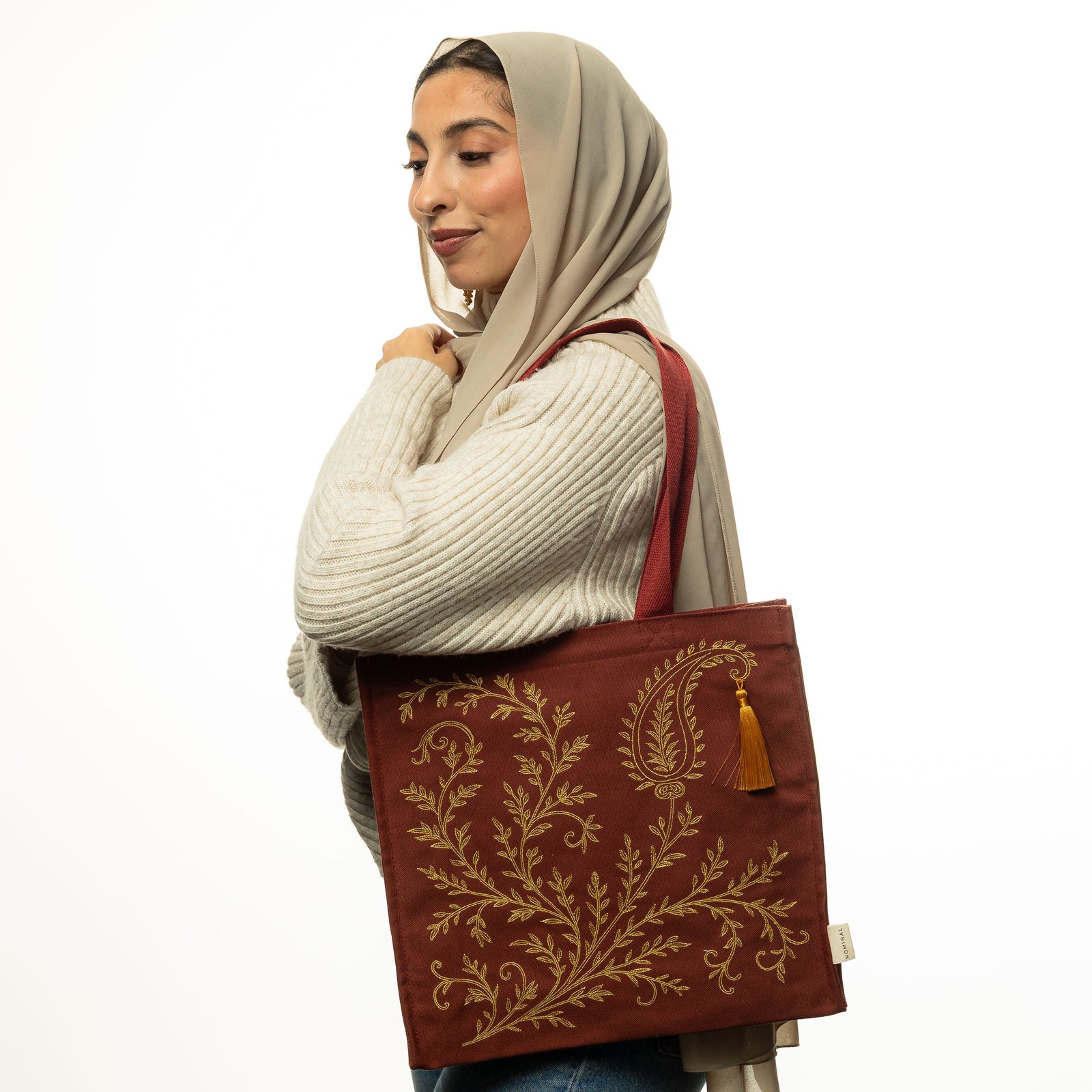 Photo of the model carrying the maroon Mehndi Paisley Tote on their left shoulder.