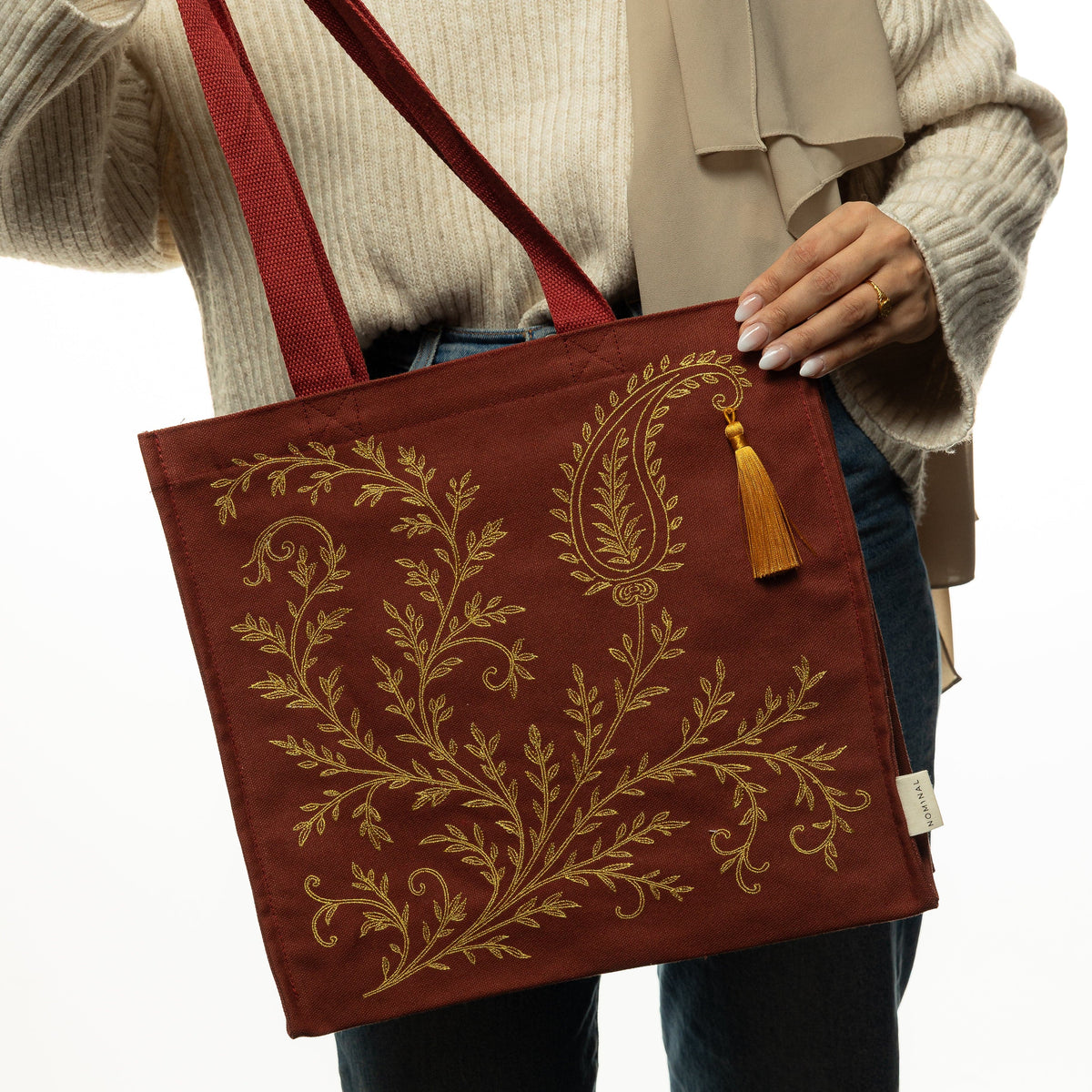 Photo of the model holding the maroon bag.