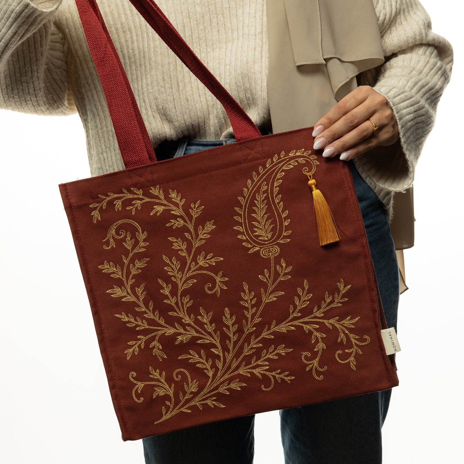 Photo of the model holding the maroon bag.