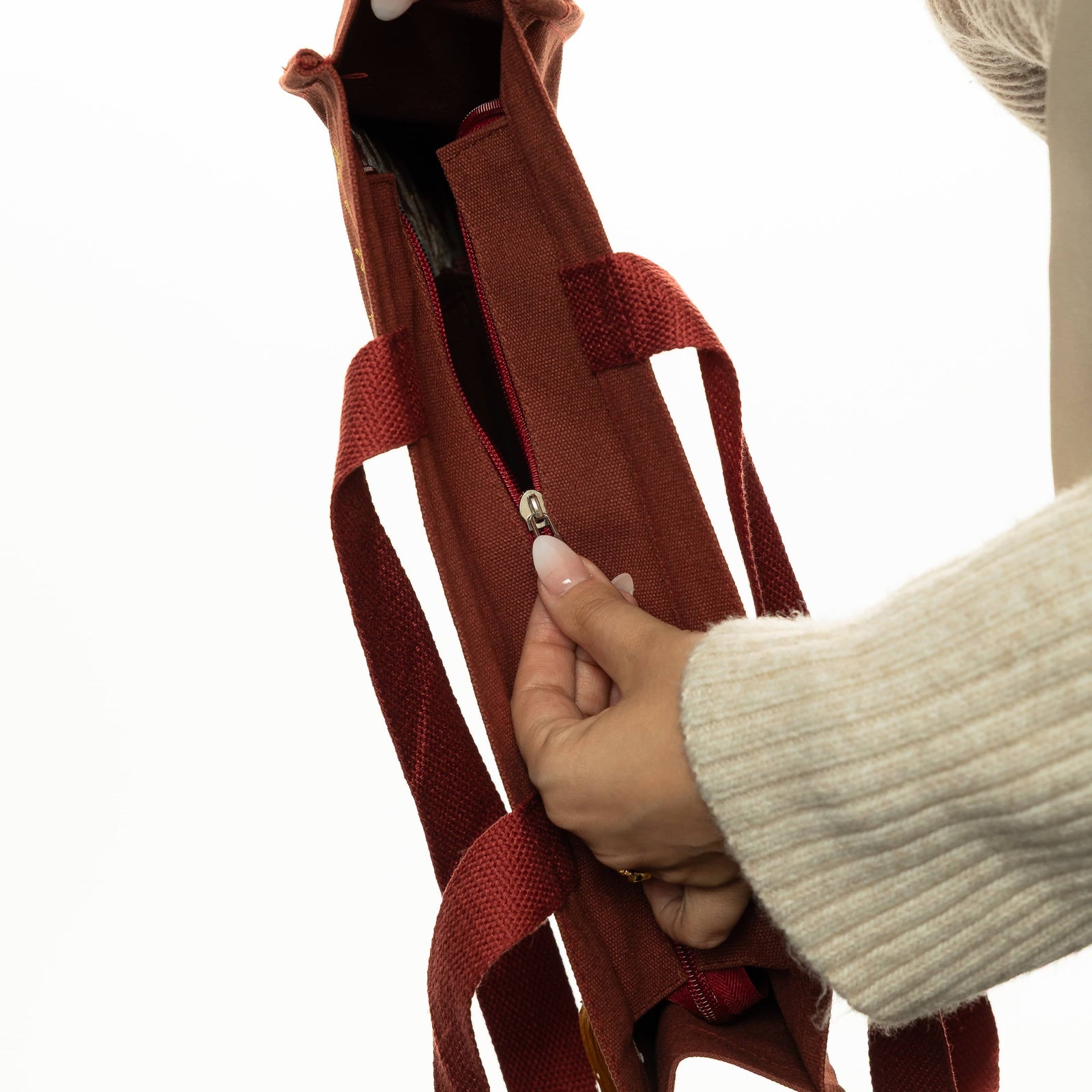 Close up photo of the model opening the zipper of the tote bag.