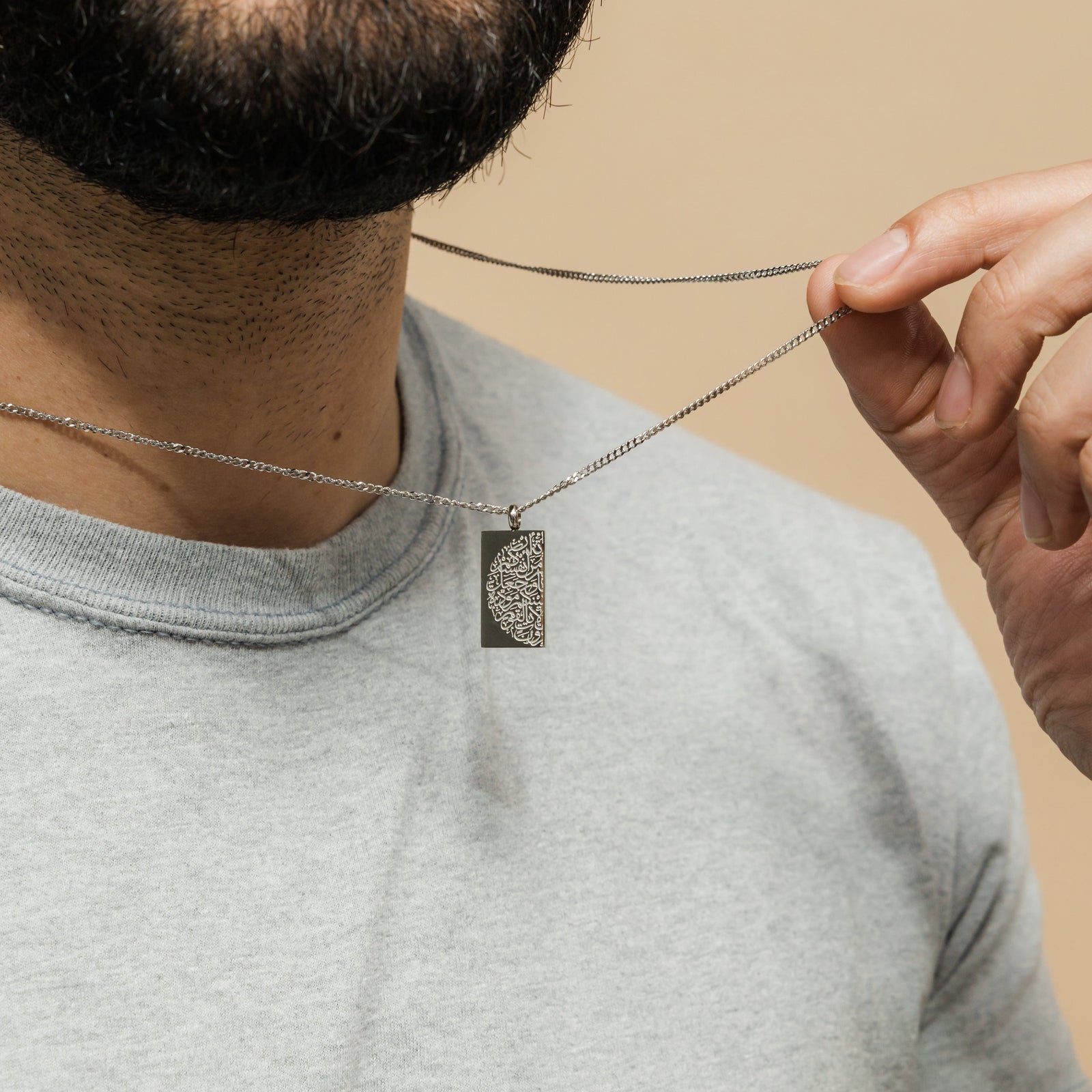 Close up of the silver "Tranquility in Them" Necklace as worn by the male model.