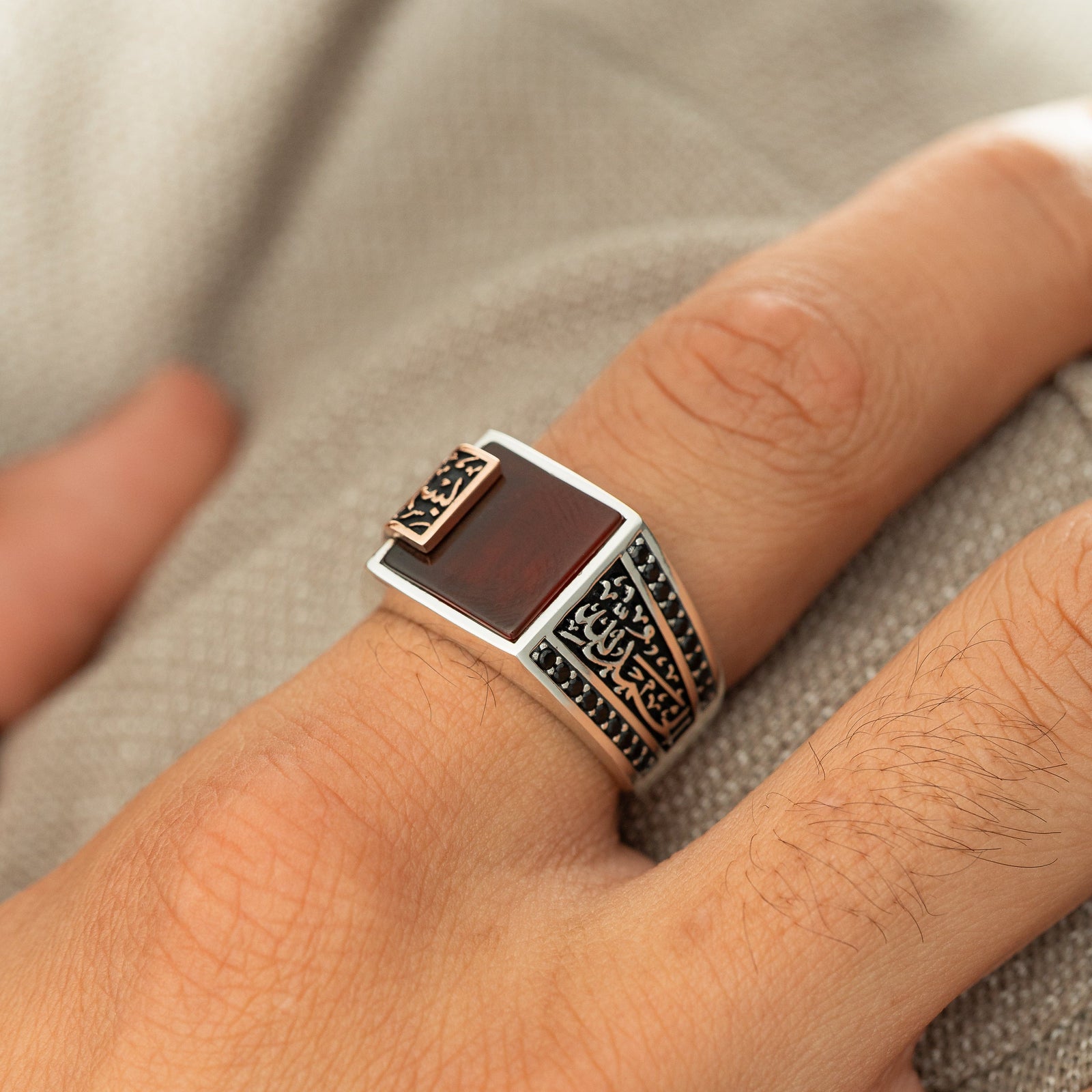 Close up of the Bismillah, Alhamdulillah Agate Sterling Silver Ring as worn by the model on their index finger.