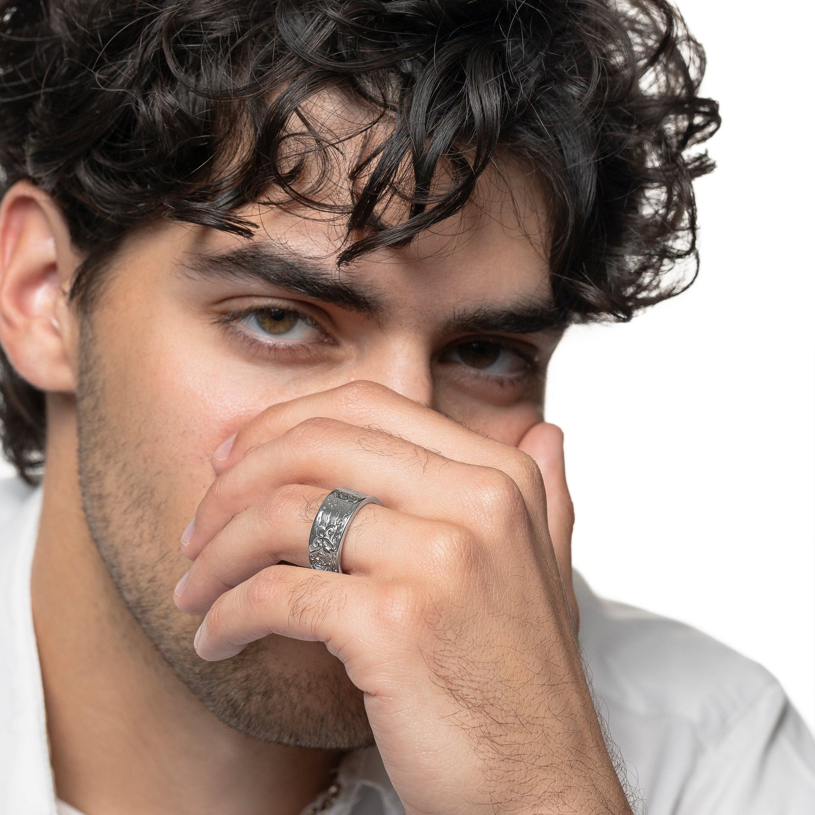 Model covers half of their face with their left hand. The model is wearing the silver Be Happy About Today Poem Ring on their left ring finger.