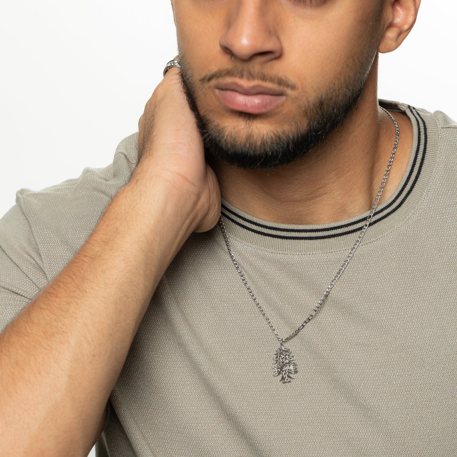 Man wearing the ‘Freedom is the Soul’ Lebanon Cedar Necklace | Men, showing the silver cedar tree pendant against a neutral shirt.