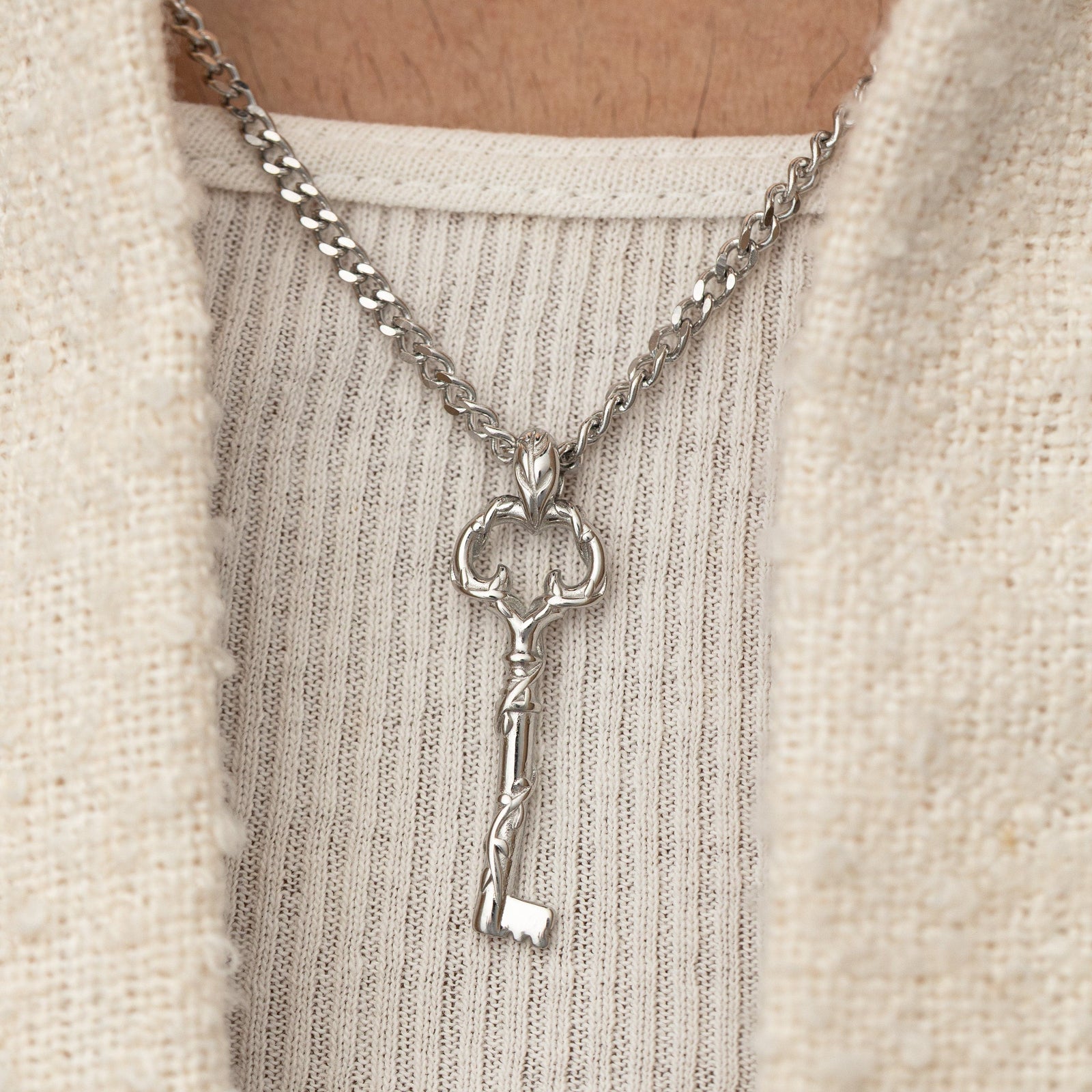 Man wearing the stainless steel Palestine Key of Return Necklace, styled over a textured cream shirt.