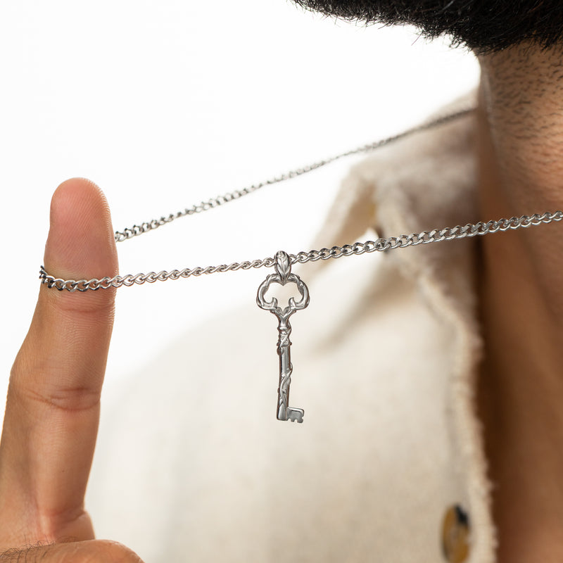 Close-up of a hand lifting the Palestine Key of Return Necklace by the chain.
