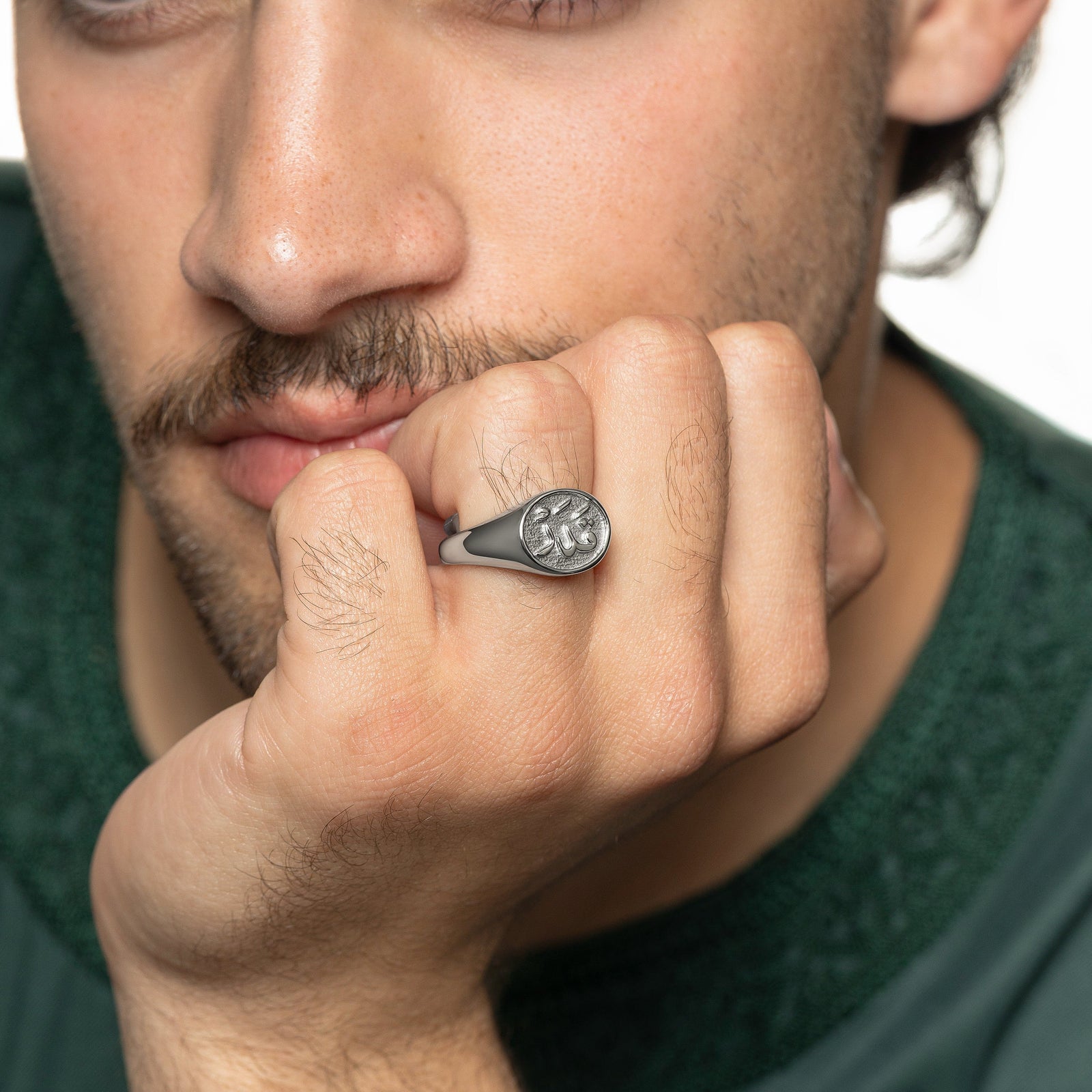 Model rests their chin on their left hand. The model is wearing the silver Qadr | Destiny Ring | Men on their left ring finger.