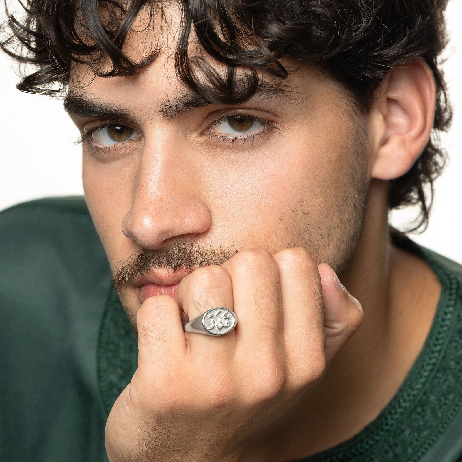 Model rests their chin on their left hand. The model is wearing the silver Qadr | Destiny Ring | Men on their left ring finger.