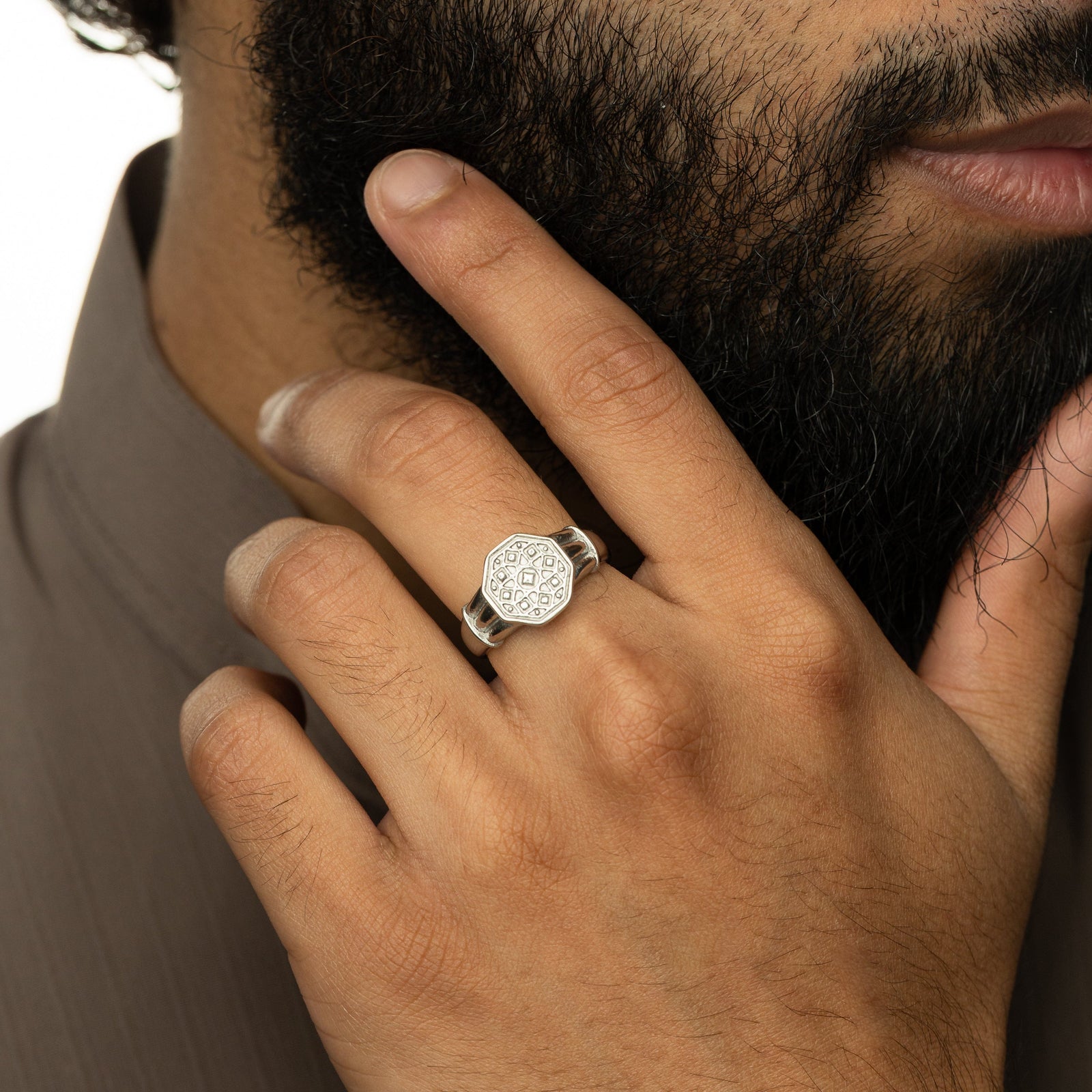 Model touches the side of their face and chin showing the Syrian Mosaic Ring | Men they are wearing on their middle finger.
