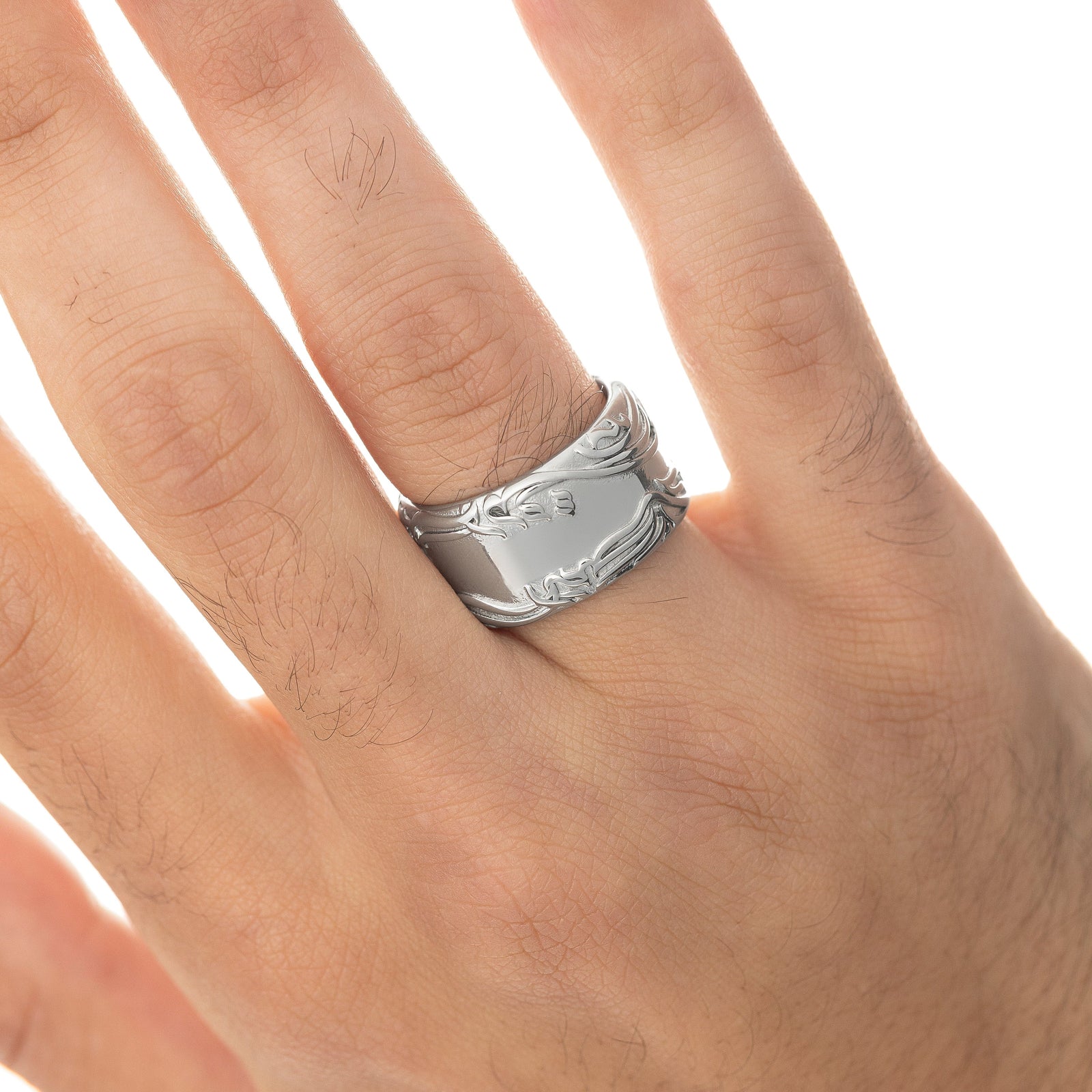 Close up of the model's right hand. The model is wearing the silver "The wound is where light enters you" Rumi Ring on their right ring finger.