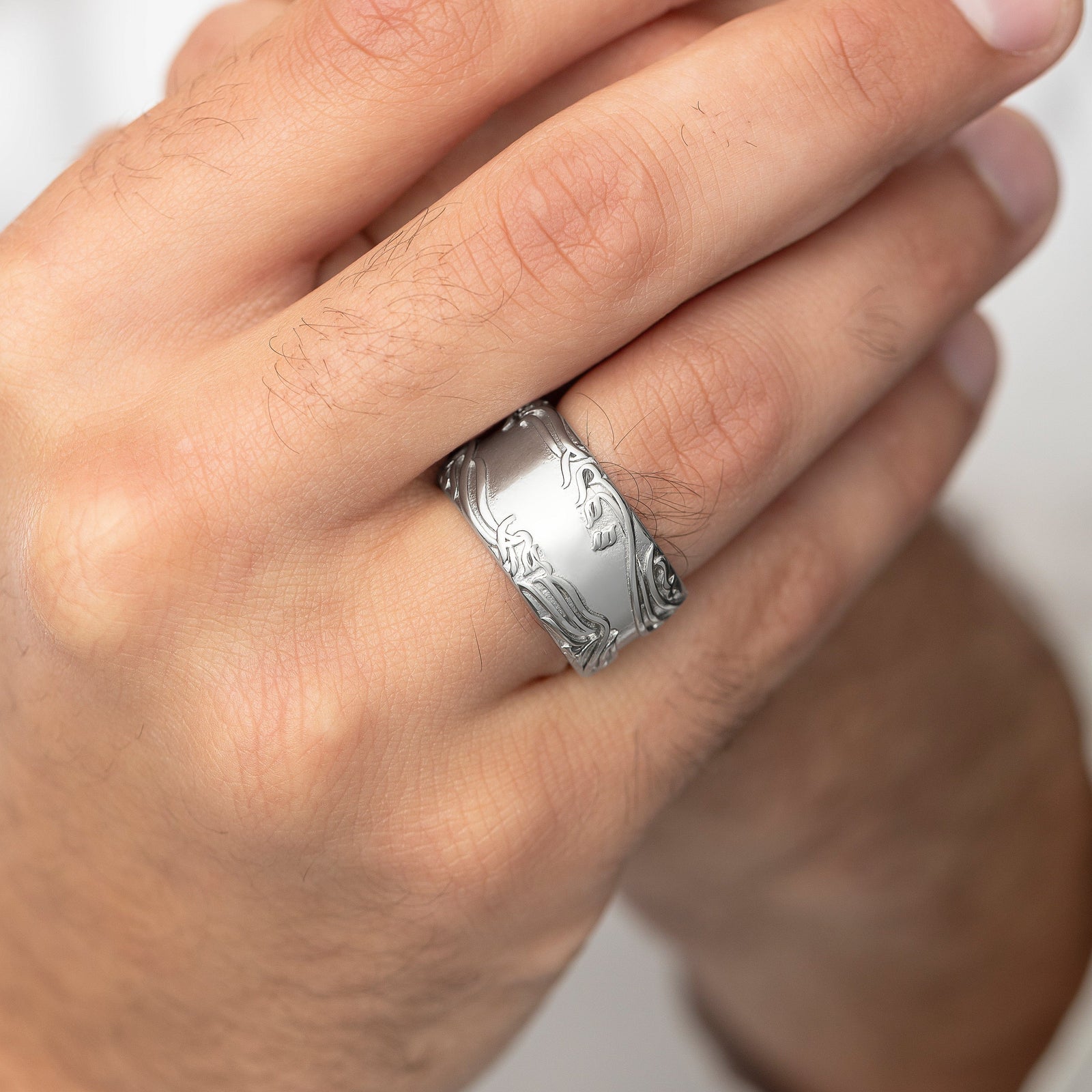 Close up of the silver "The wound is where light enters you" Rumi Ring worn by the model.