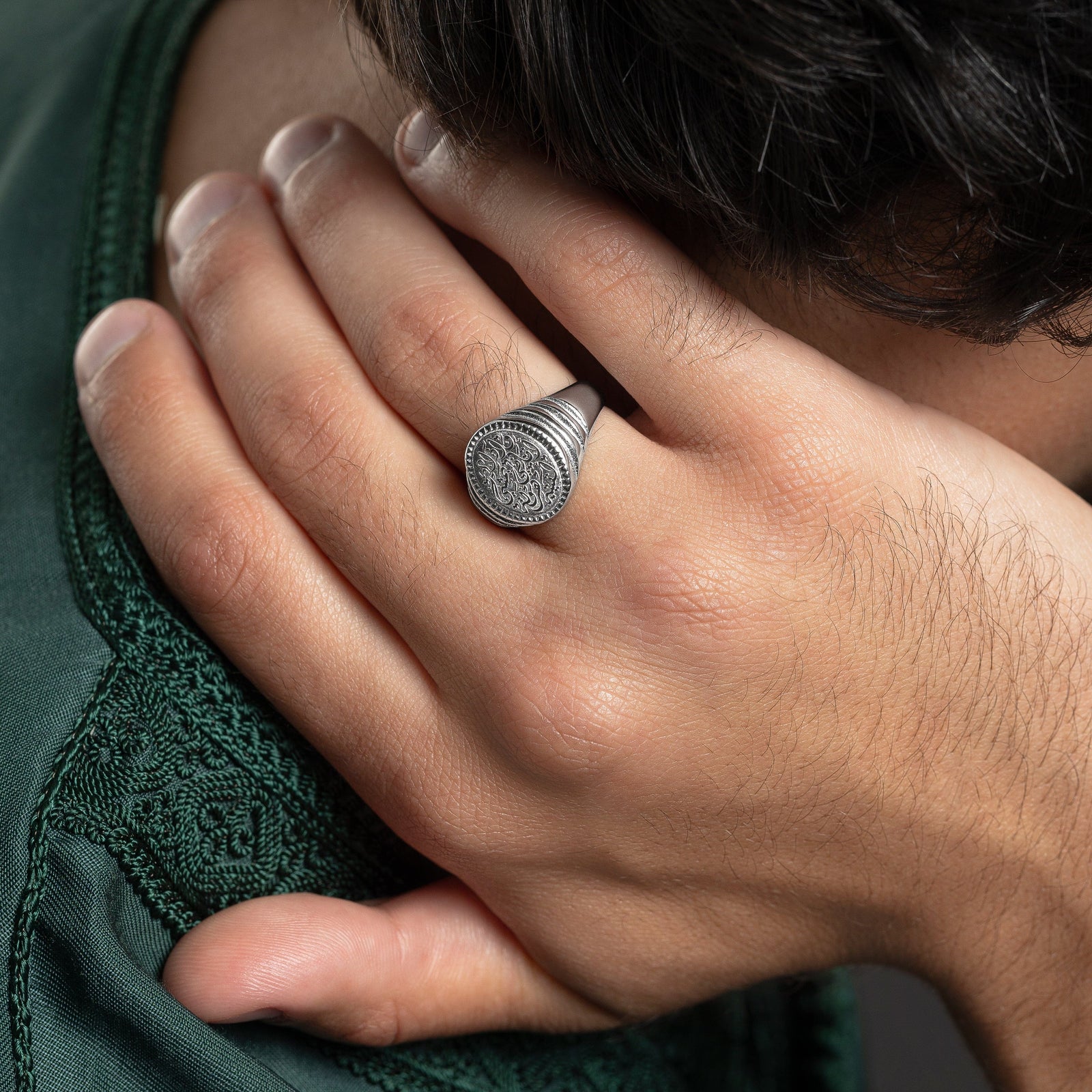 Photo of model's right hand touching the back of their neck. The model is wearing the silver "Walk to Me, and I'll run to you" Medallion Ring | Men on their right ring finger.