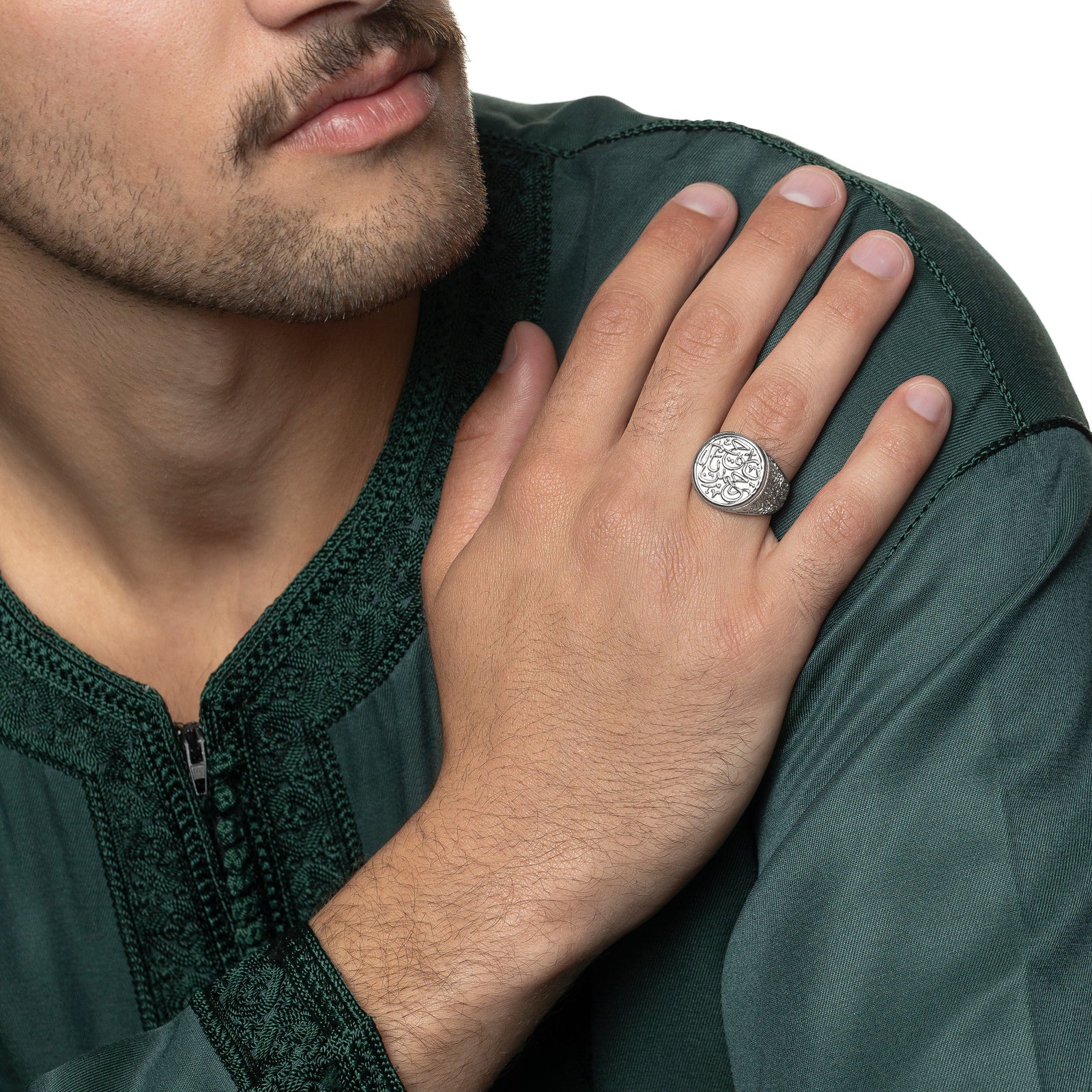 Model is touching their left shoulder with their right hand. The model is wearing the silver "Ya Rahman, Ya Raheem" Ring on their right ring finger.