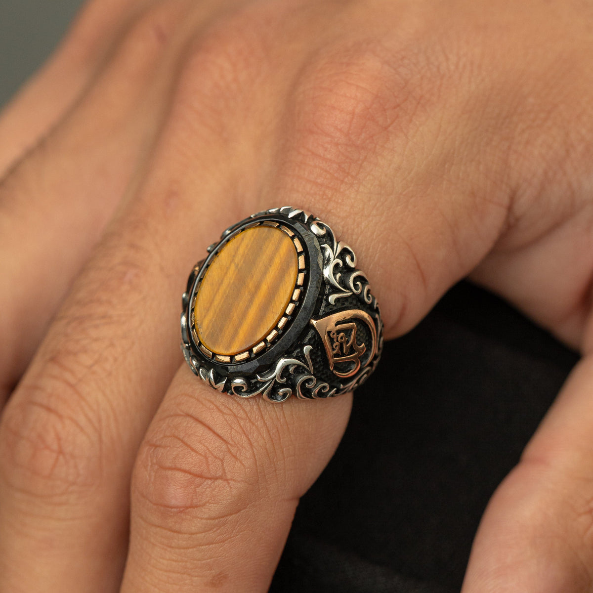 Men’s silver ring with a tiger's eye stone and an Arabic calligraphy detail of the word ‘Allah,’ surrounded by ornate black and silver engravings.
