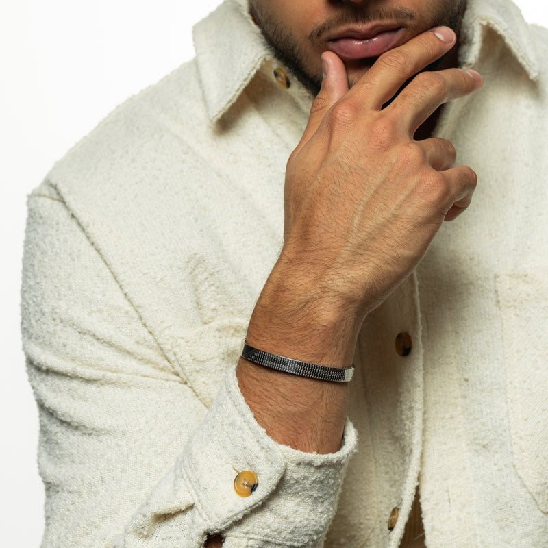 silver Keffiyeh Bracelet worn on the wrist pimage_ showing the engraved keffiyeh pattern across the band.