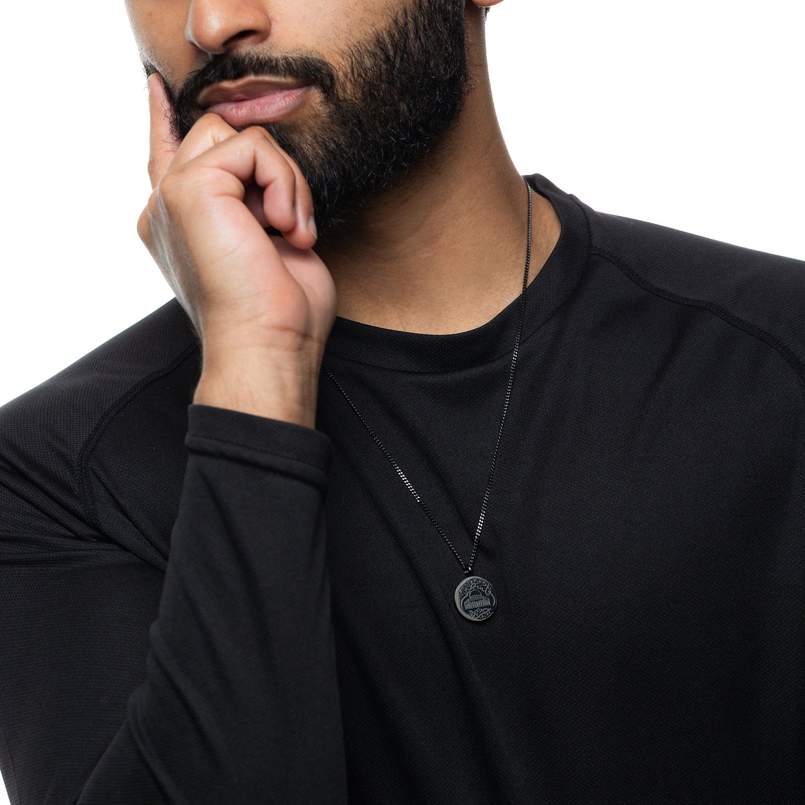 Man wearing a black long-sleeve shirt and black Al-Aqsa ‘Free Palestine’ Necklace on a white background