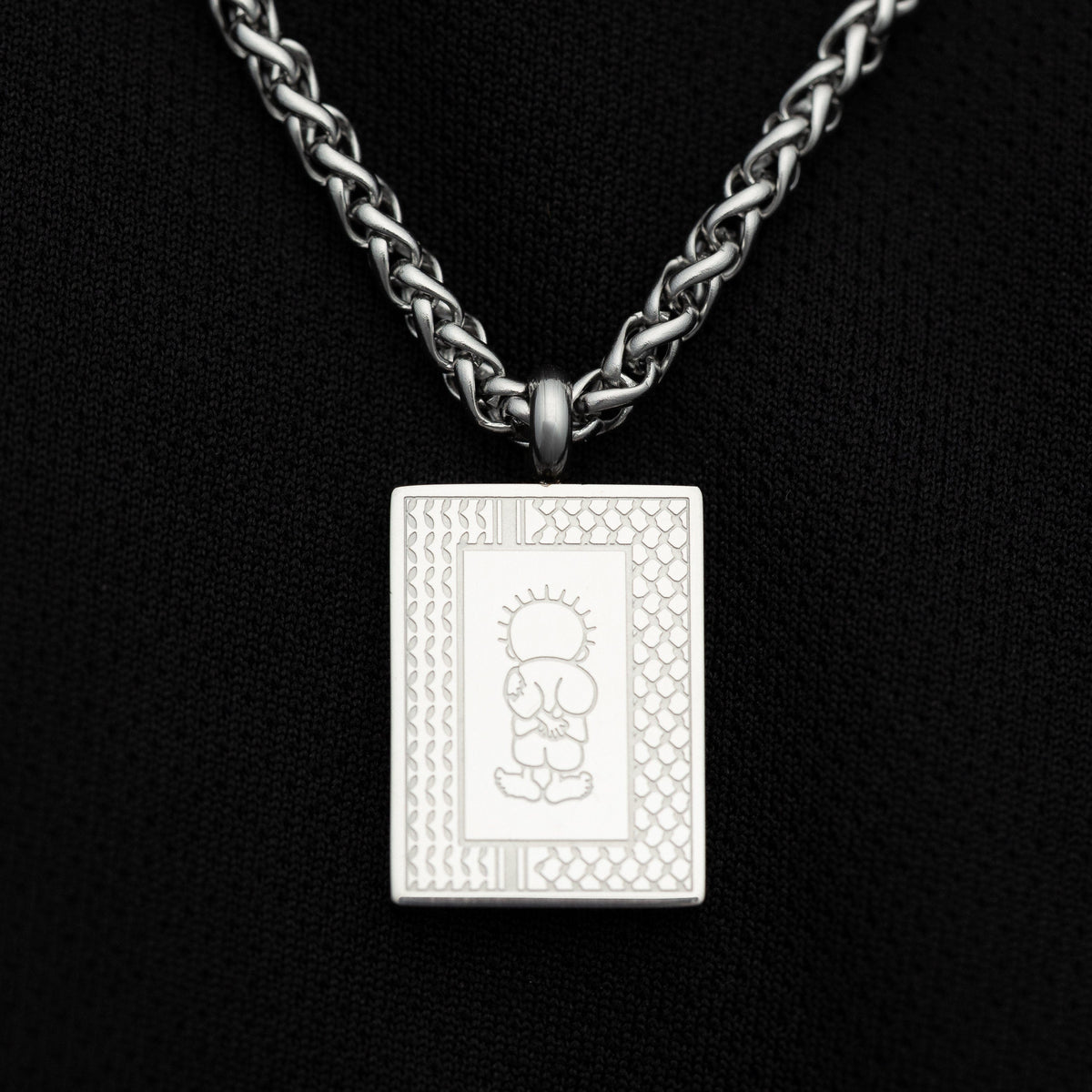 Close-up of Silver Handala Necklace on a black background