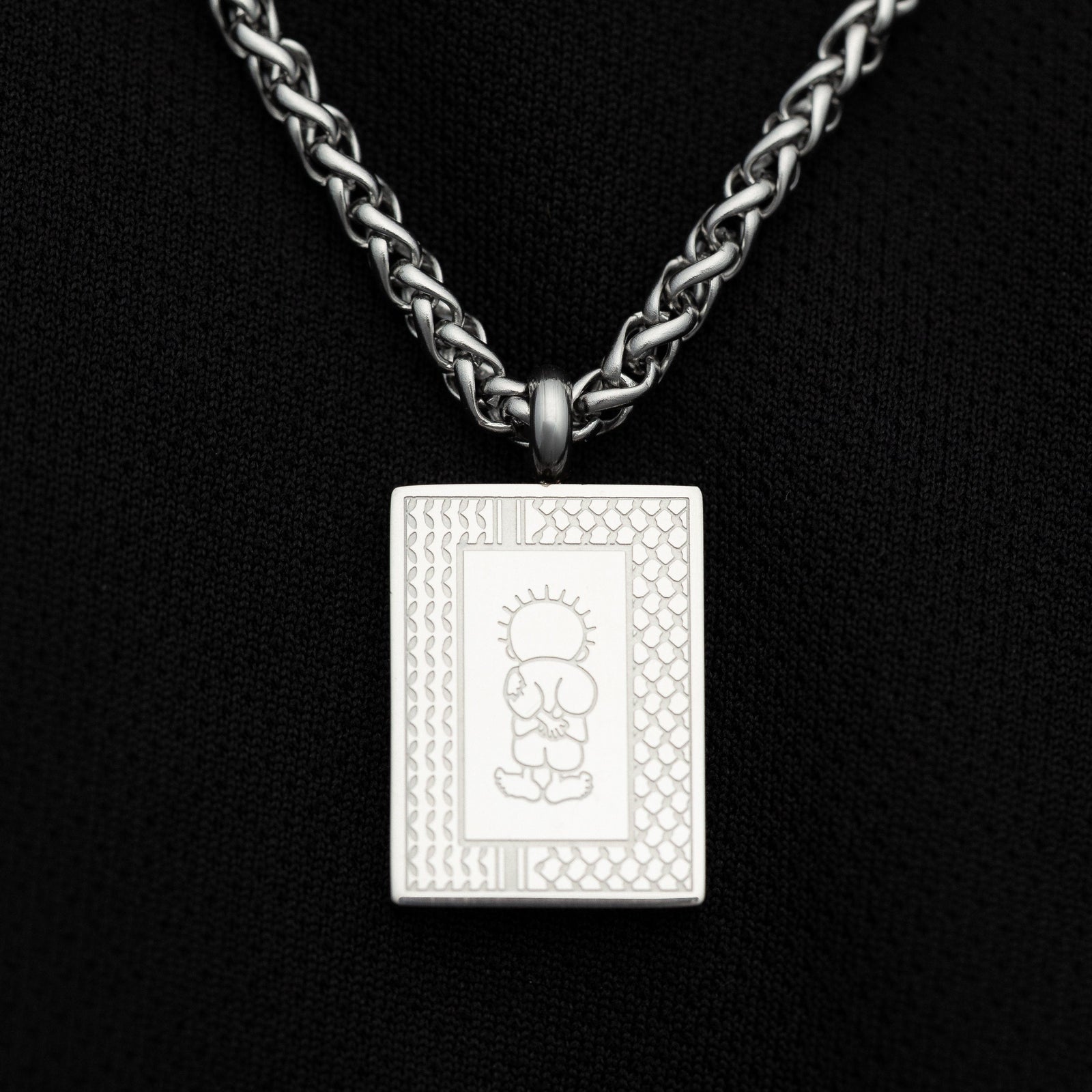 Close-up of Silver Handala Necklace on a black background