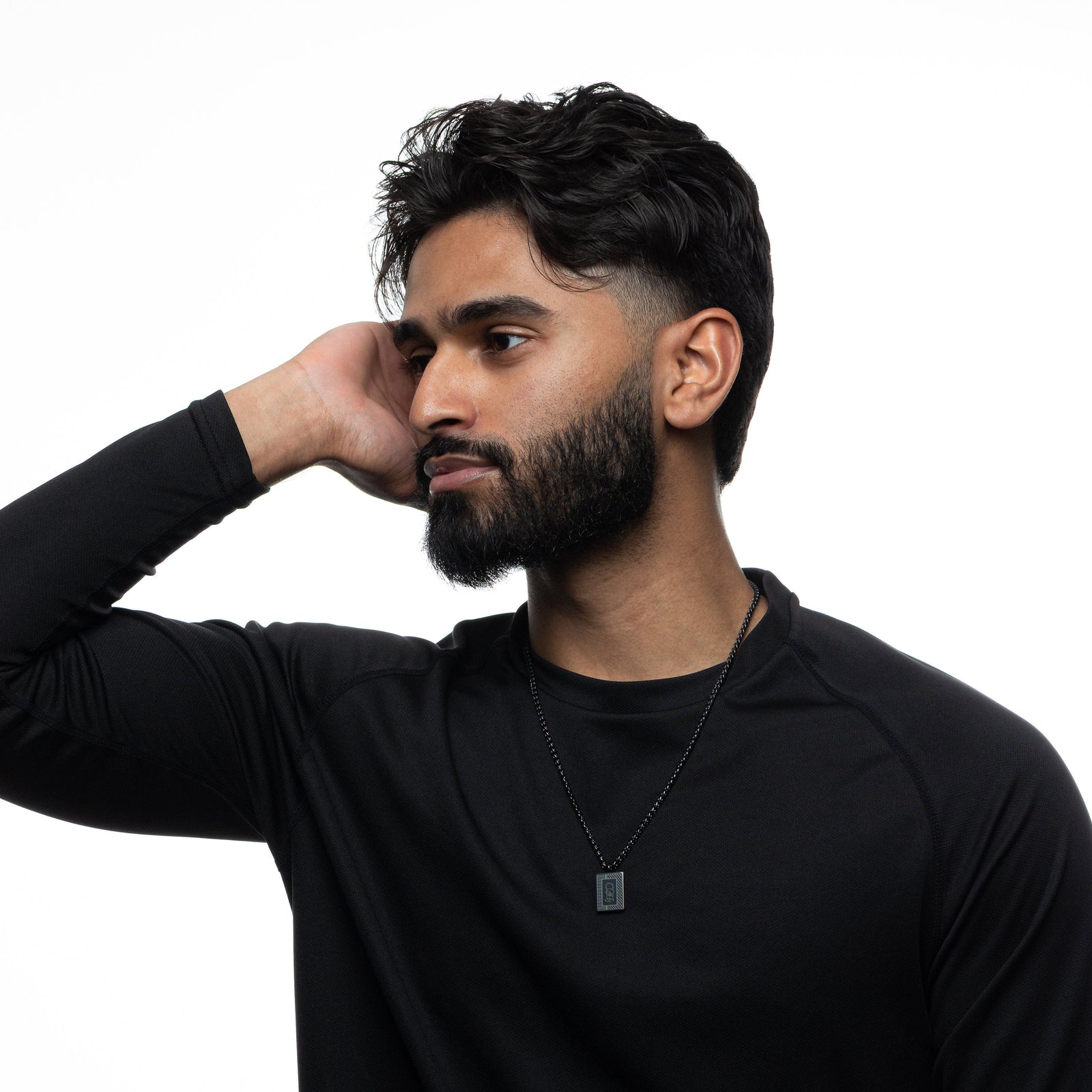 Man wearing a black long-sleeve shirt and black Handala Necklace on a white background