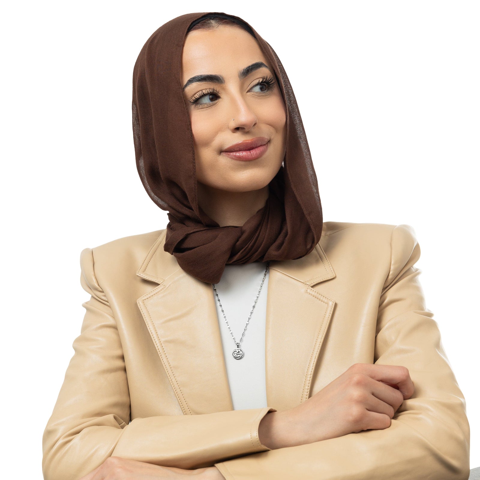 A model showcasing the silver My Mother Necklace. The pendant sits delicately on her collarbone, emphasizing the smooth Arabic script against a minimalist ensemble.