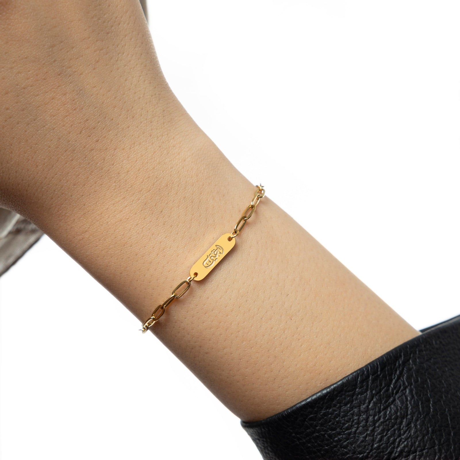 Bracelet worn snugly on wrist, showcasing Arabic "Ukhti" engraving at center with elongated gold links.