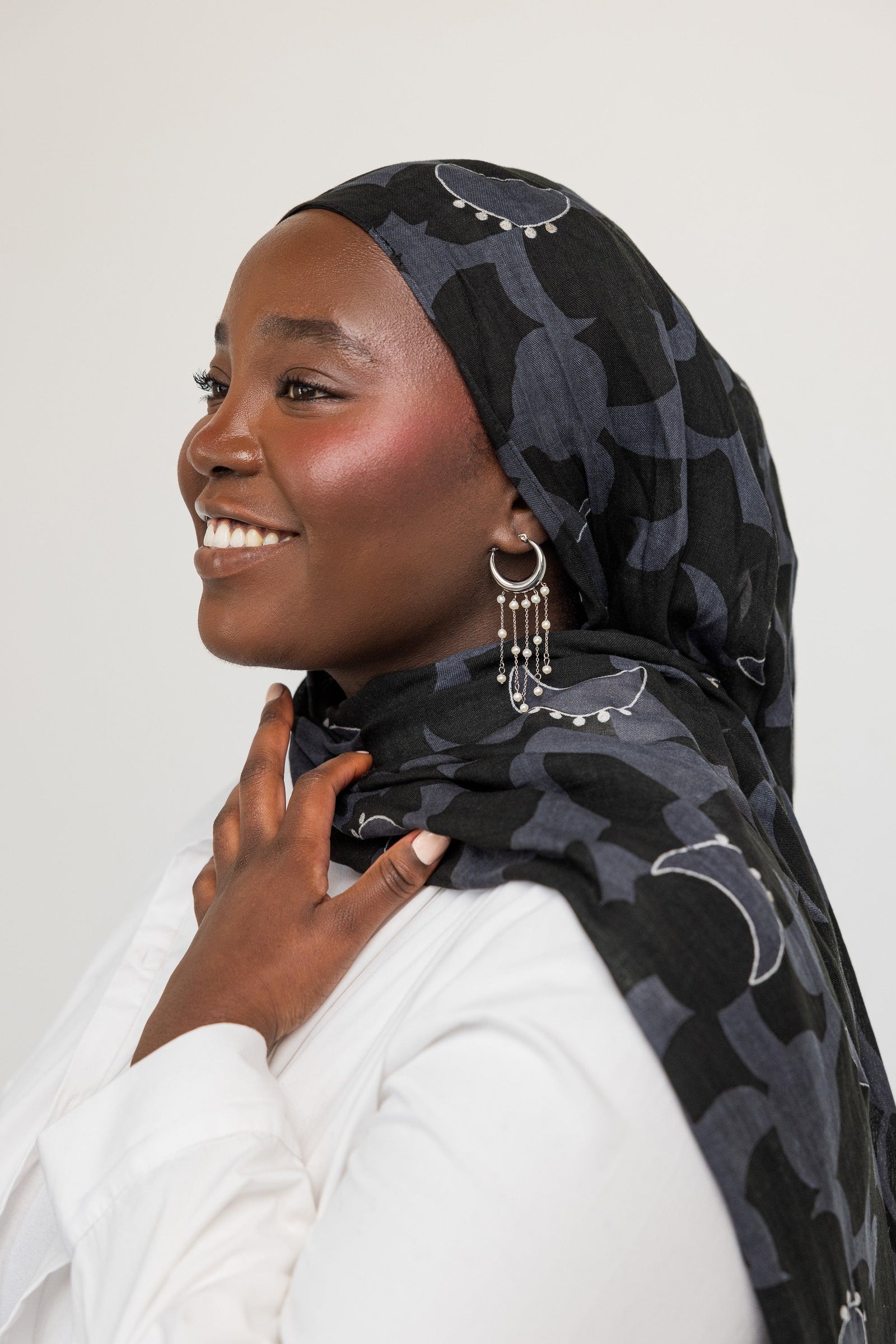 Photo of the model's side profile, the model is wearing the silver Raining Pearl Hoops on their left ear.