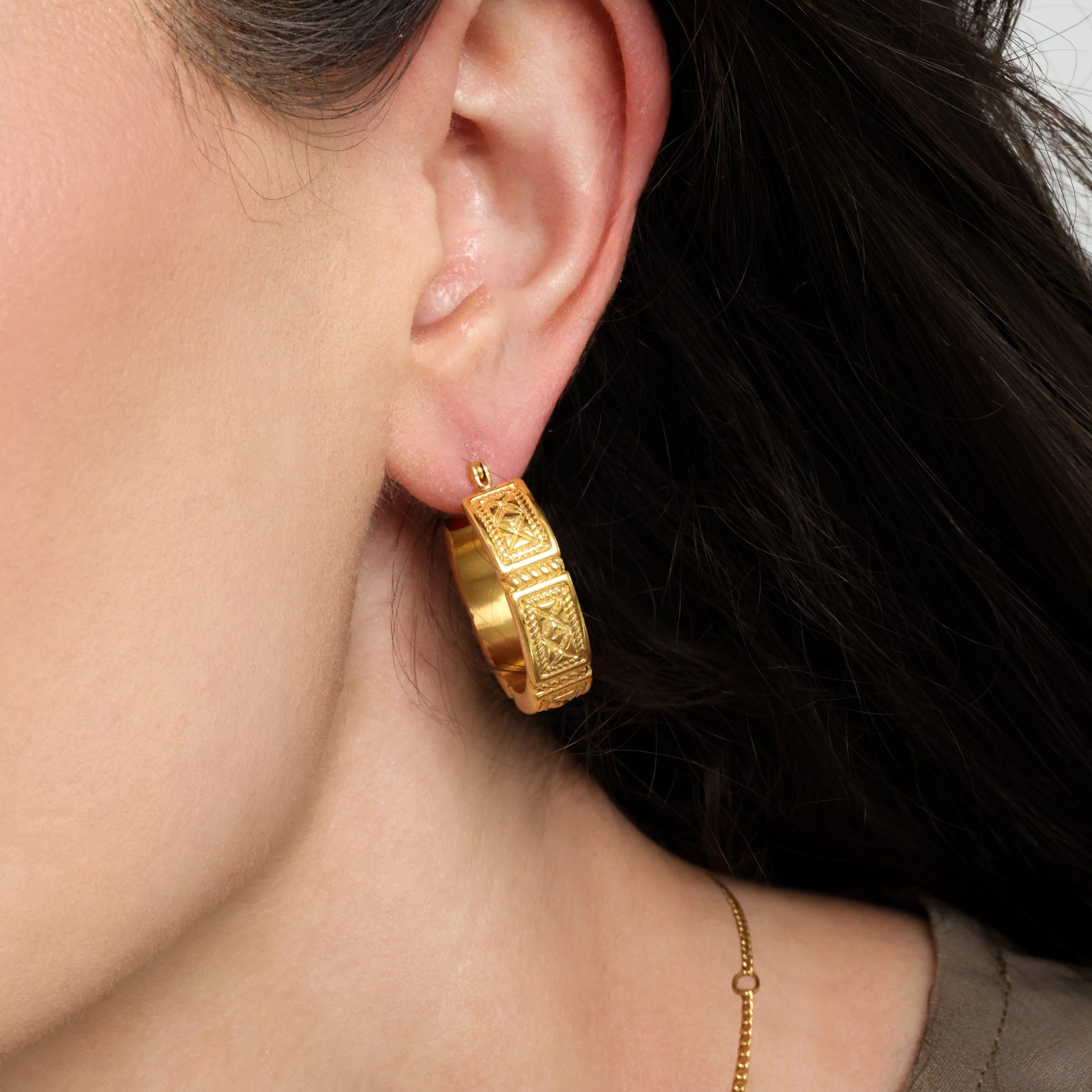 Close up of the gold Damascus Tile Earrings as worn by the model.