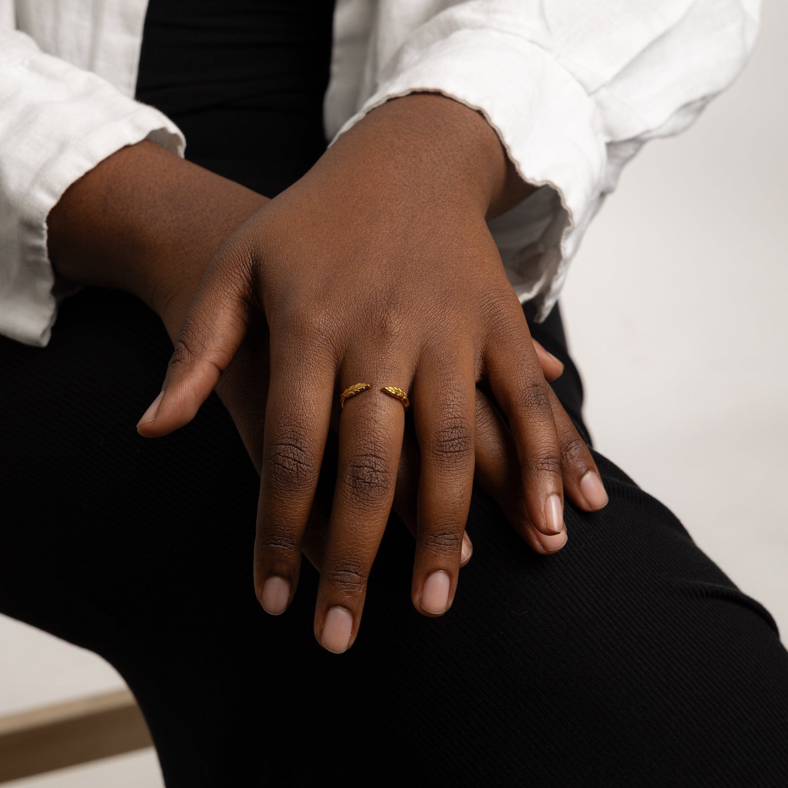 The gold Palestine Olive leaf ring V2 worn on a model's finger, showcasing the olive leaf design.